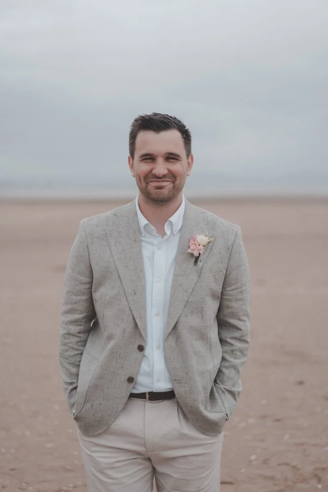 Portrait of groom on a Swansea beach during his wedding day