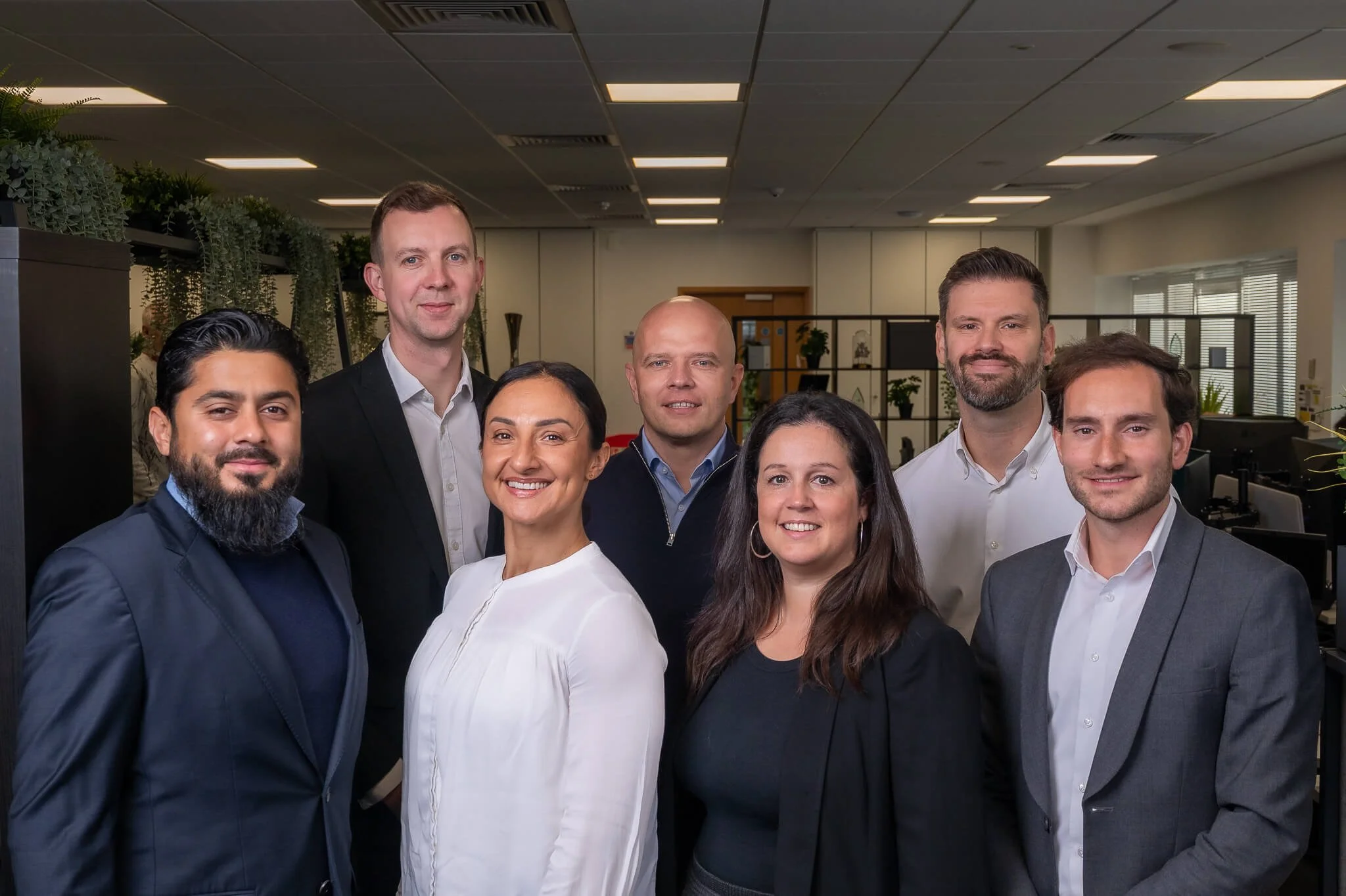 POD management team standing together in office, representing trusted and professional property management experts.