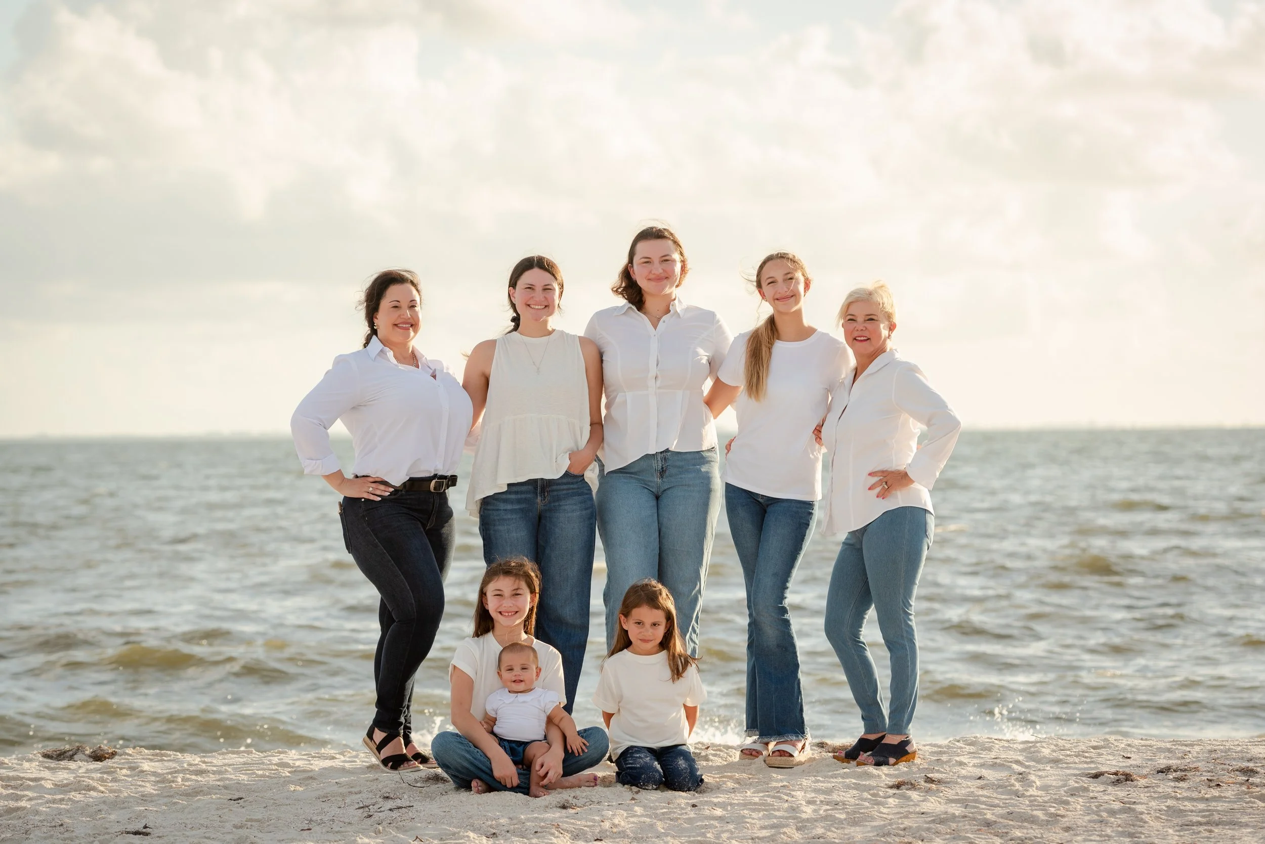 Mother, daughters, and grandmother posing on the beach at Cypress Point Park