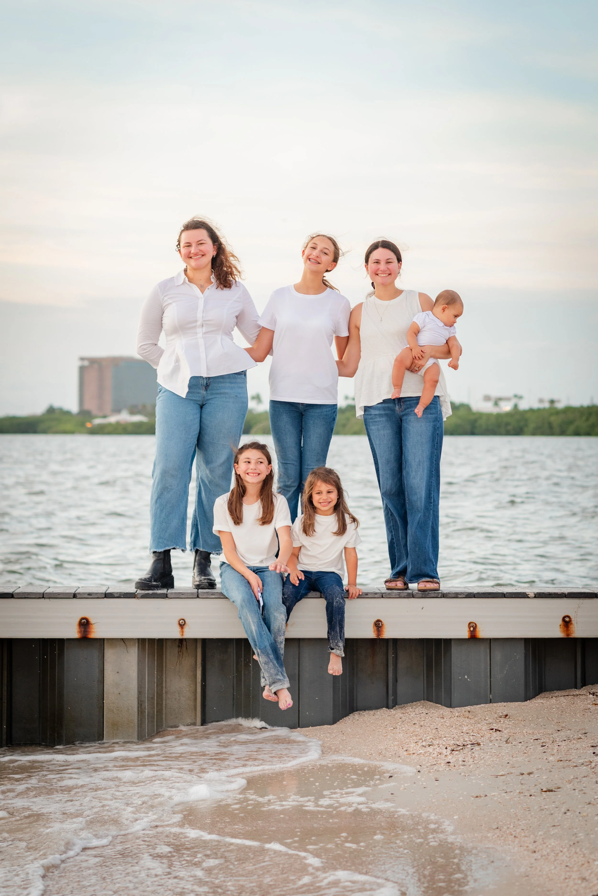 Sisters and baby sitting on dock at Cypress Point Park, Tampa FL