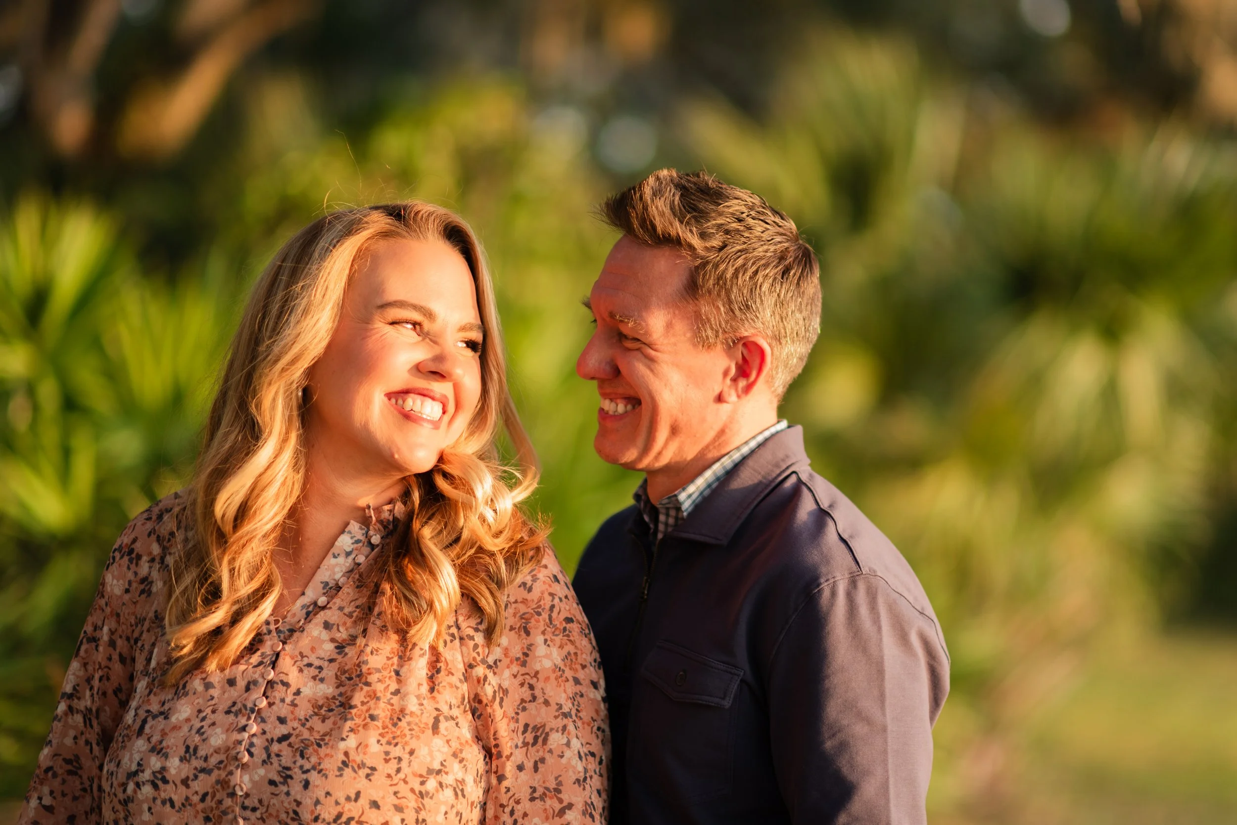 Couple smiling at each other in golden hour light