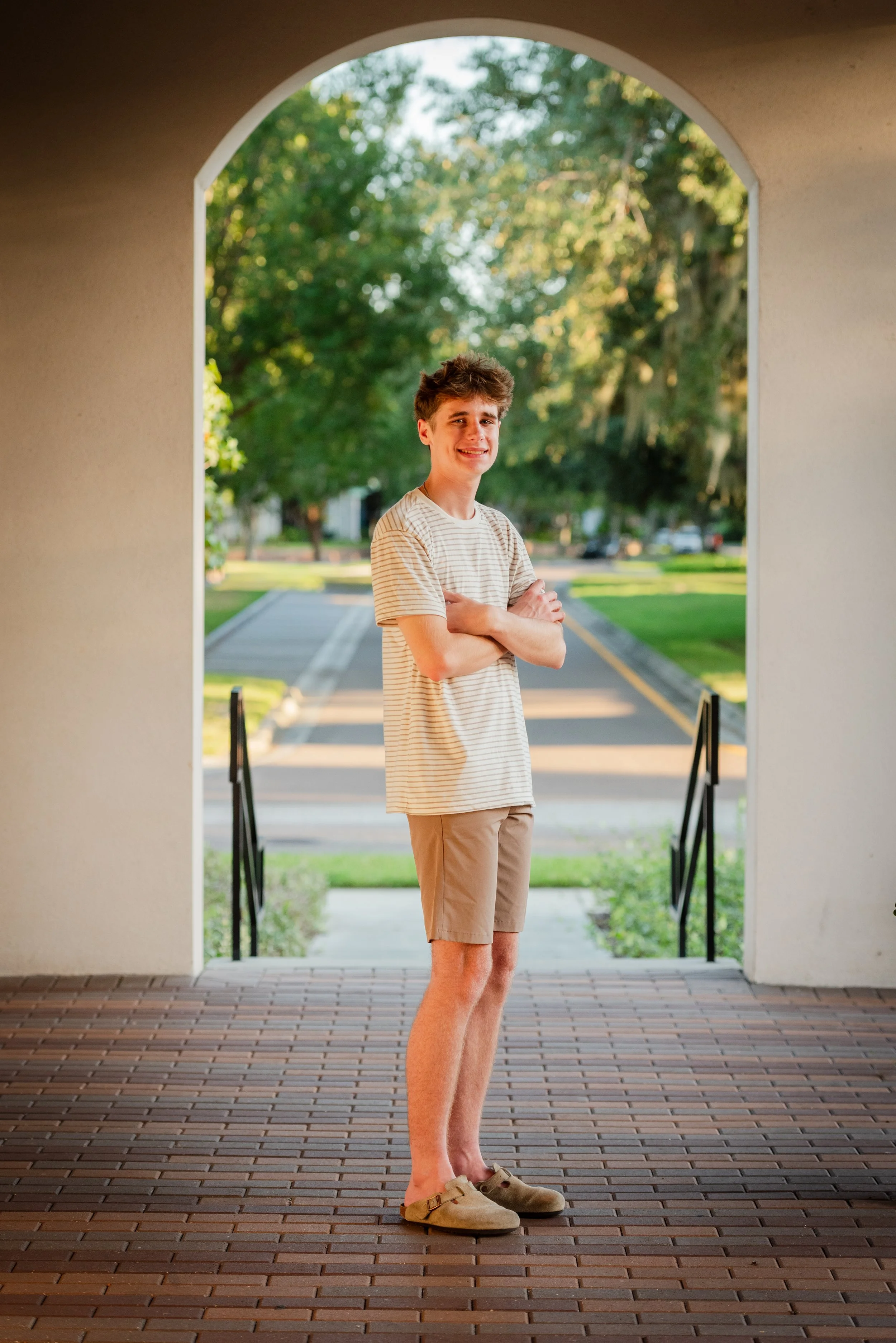 Teen son standing under stone archway at Starling Clubhouse, FishHawk