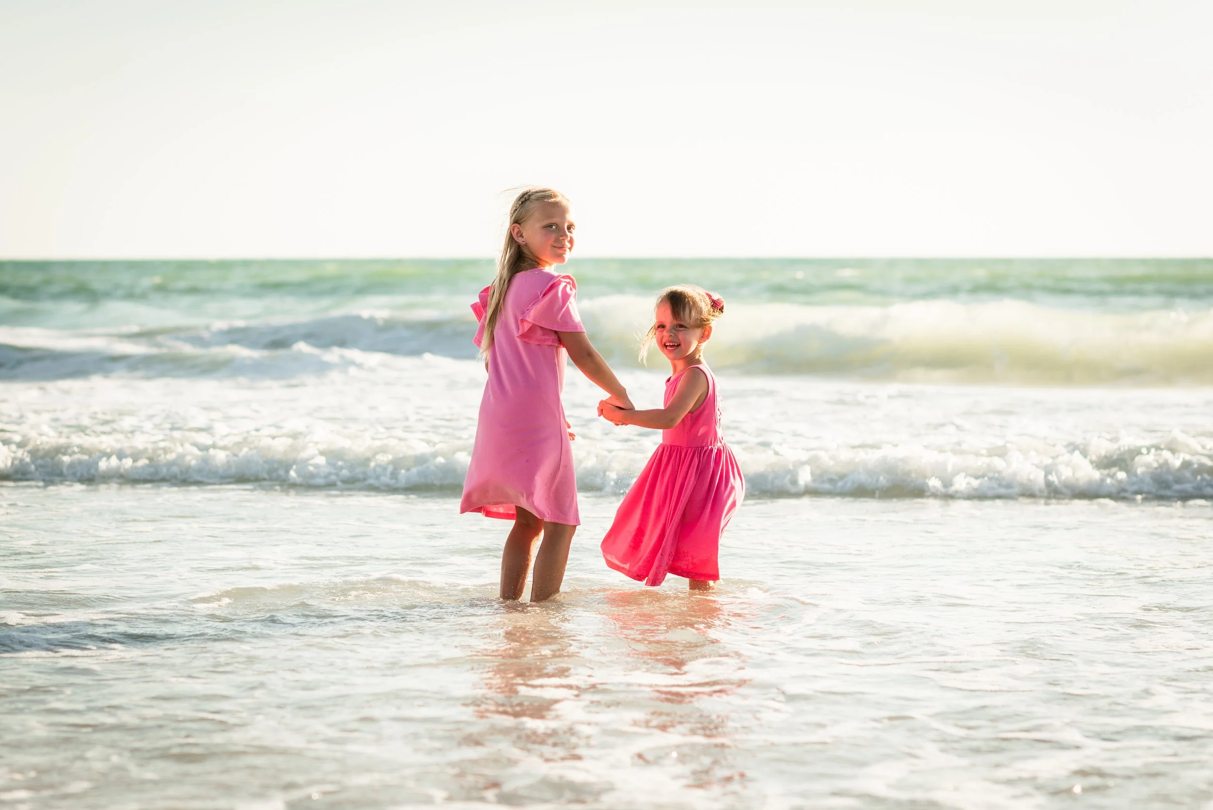 Two sisters holding hands in the ocean waves, Coquina Beach FL