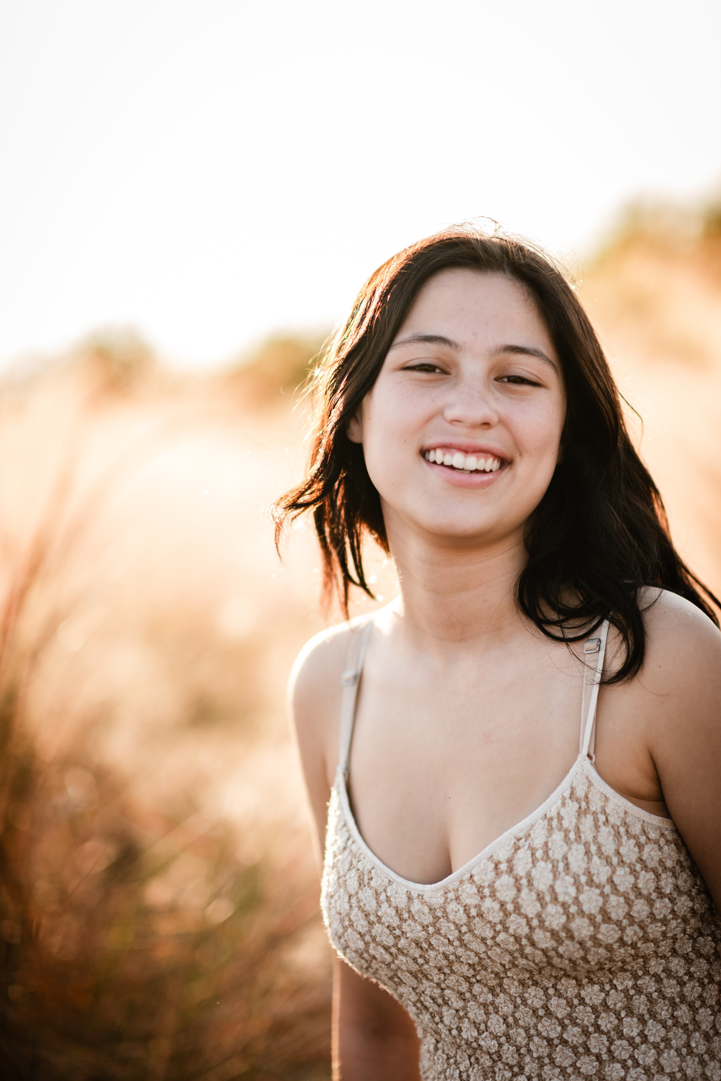 Teenage daughter smiling in golden hour light at Cypress Point Park, Tampa