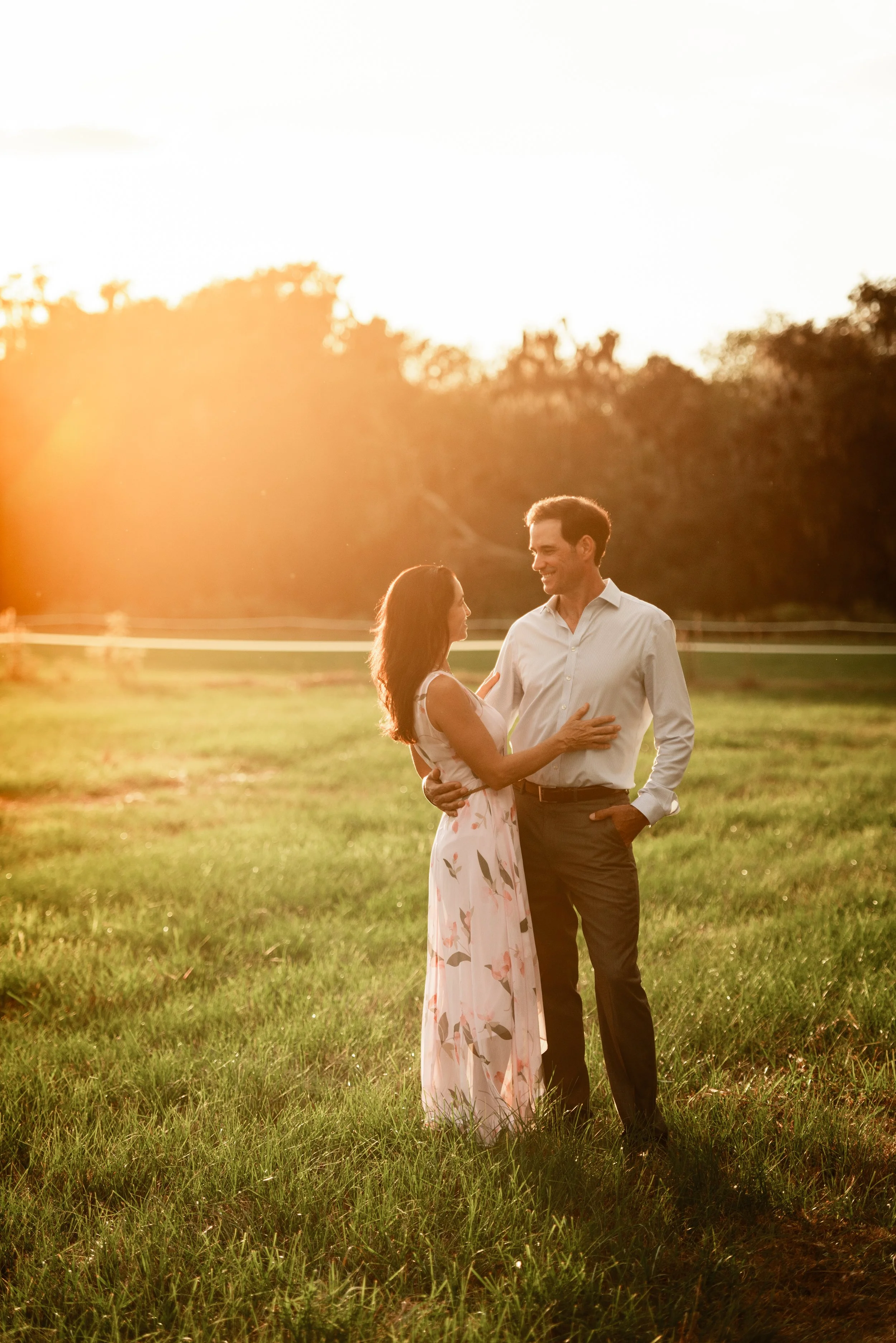 Couple embracing in a sunlit field during golden hour, Lithia FL