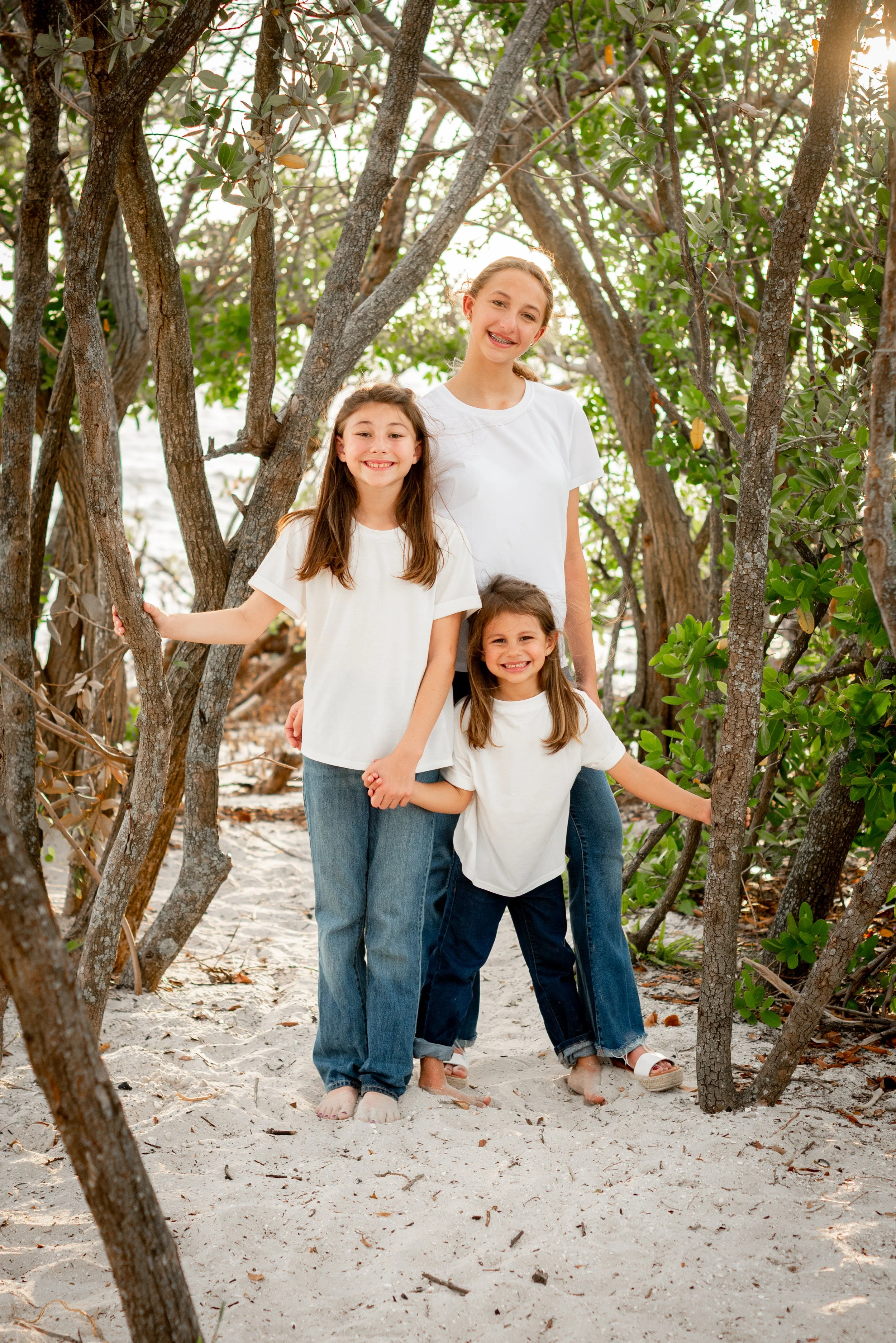 Three sisters standing together in mangrove trail at Cypress Point Park