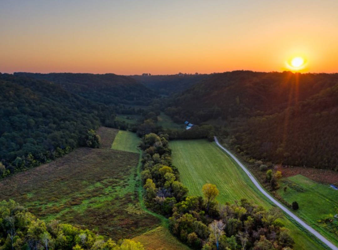 countryside with sunset behind hills