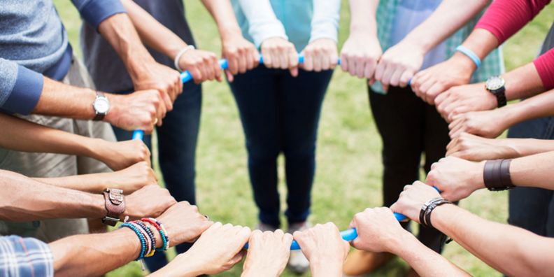 multiple hands holding onto a large circular ring