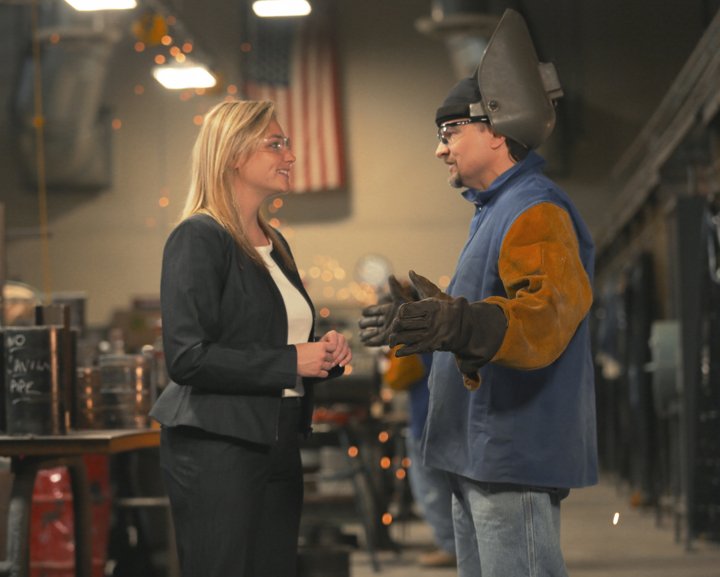 Photo of a woman talking to a man in a shop.
