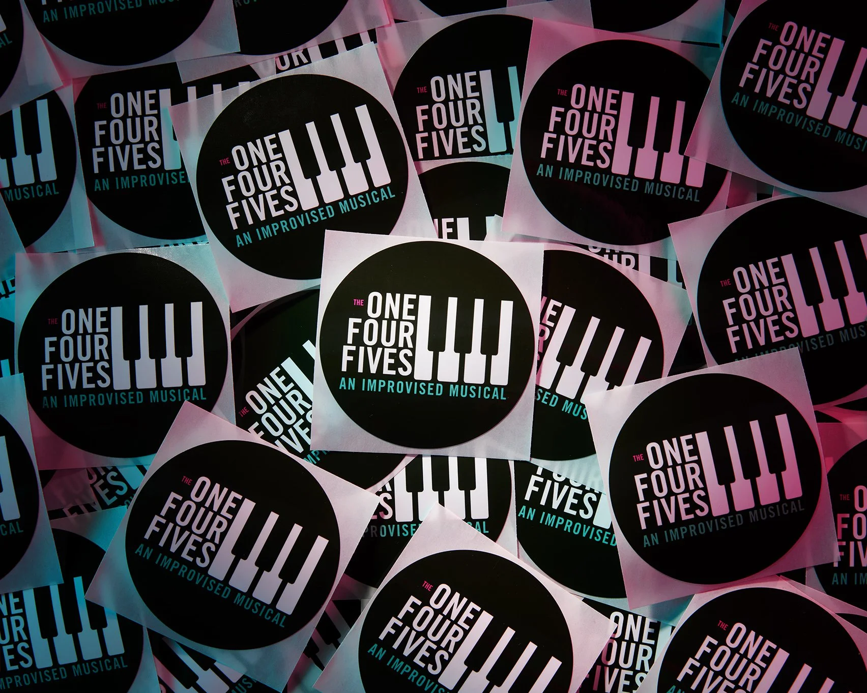 Commercial product photography. Group of promotional stickers under teal and pink light.