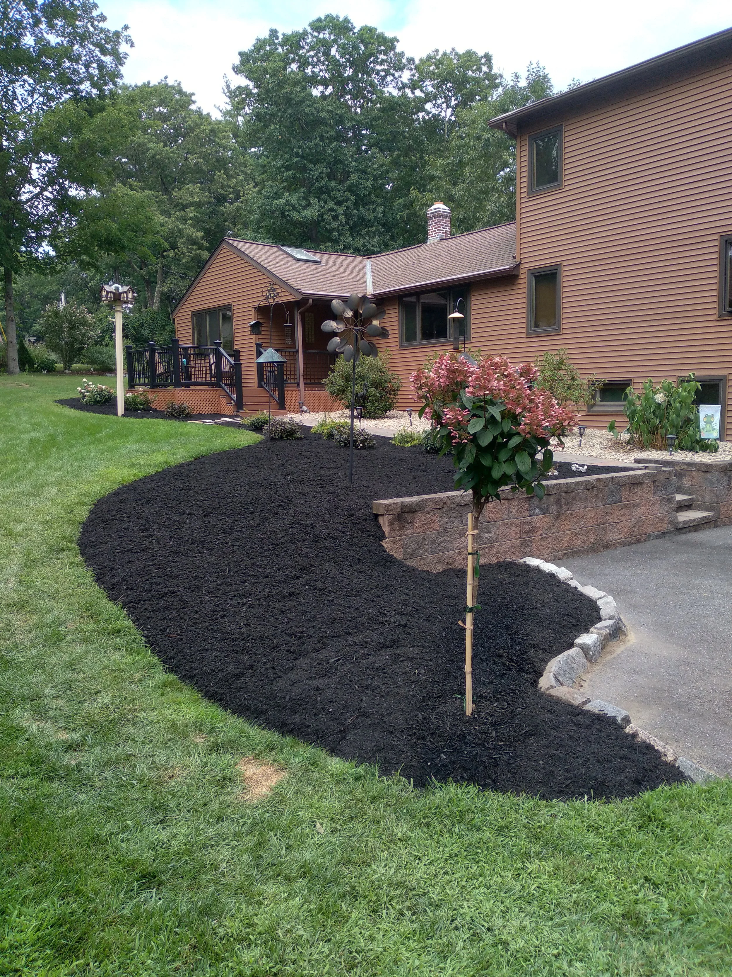 Bark mulch, plantings, and decorative stone.