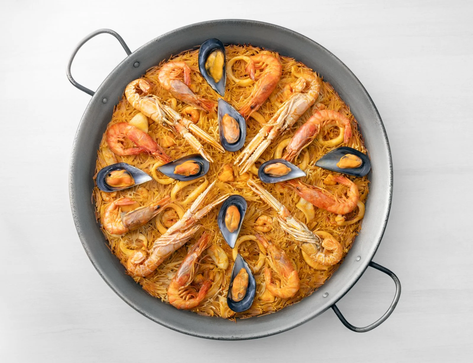 Fideuà Silomar cocinada en pallera, fotografía gastronómica para comunicación comercial.