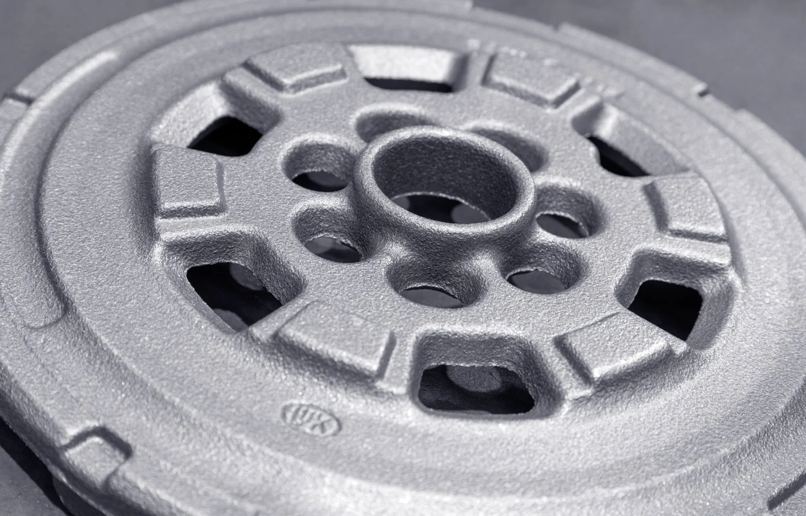 Detalle macro de una pieza metálica acabada, mostrando textura y precisión de acabado.