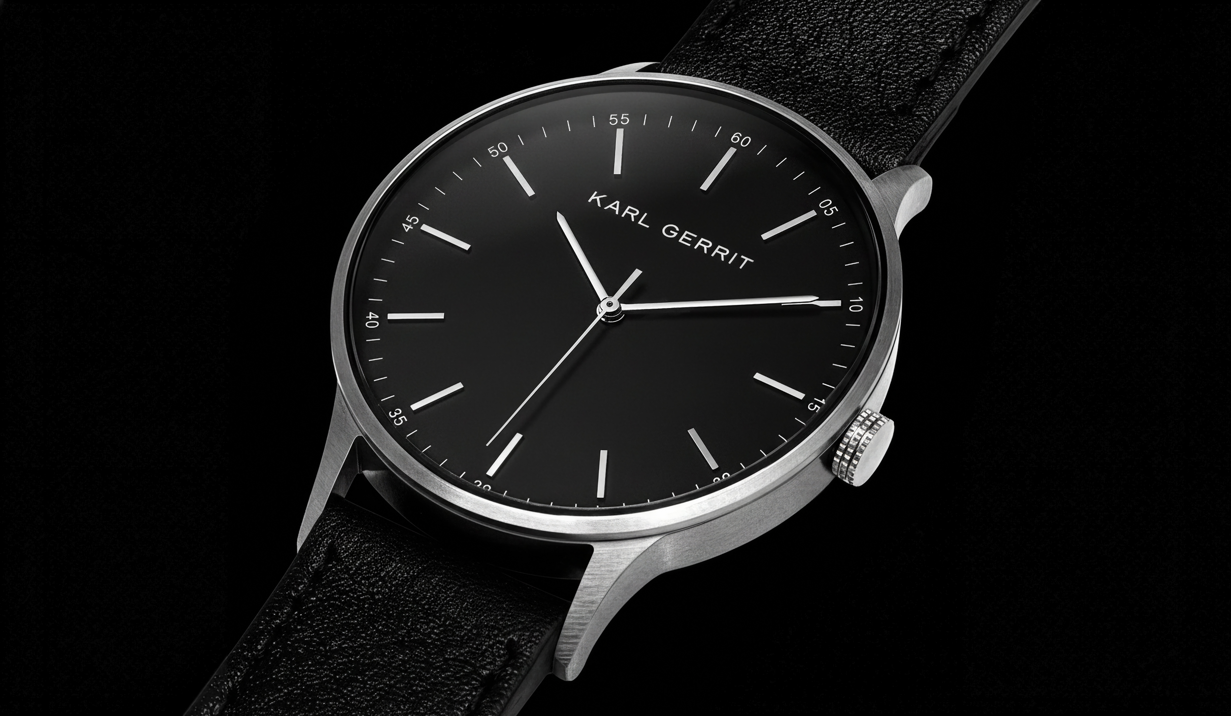 Fotografía publicitaria de producto con reloj plata y negro con pulsera de piel negragafas de sol negras, iluminadas con precisión y composición cuidada.