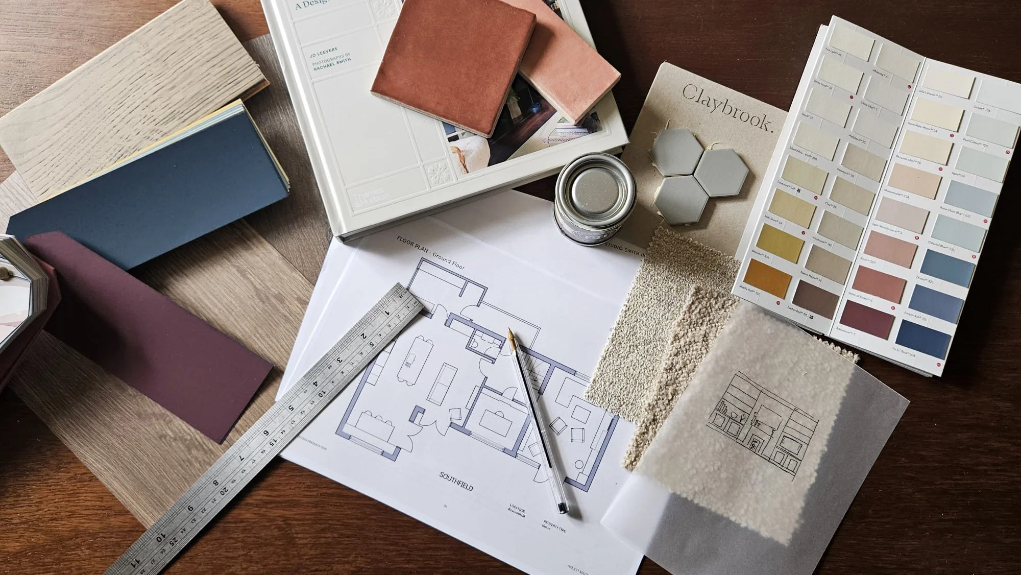 birds eye view of interior flat lay with paint and fabric samples surrounding a floorplan