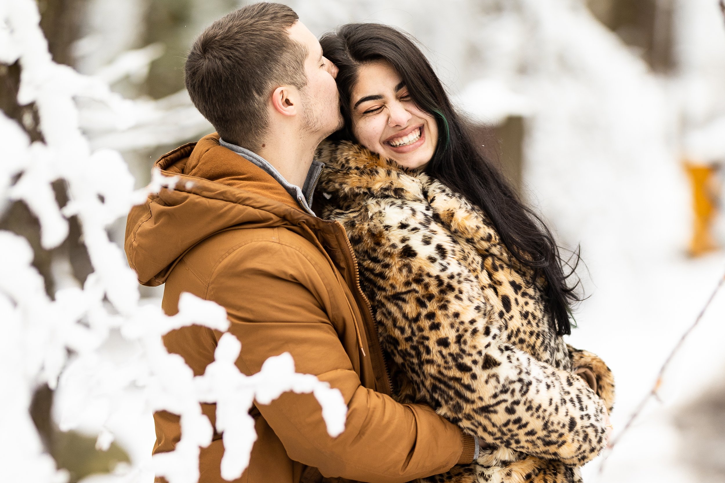 A man and woman happily celebrate their engagement in a winter wonderland in the Smokies