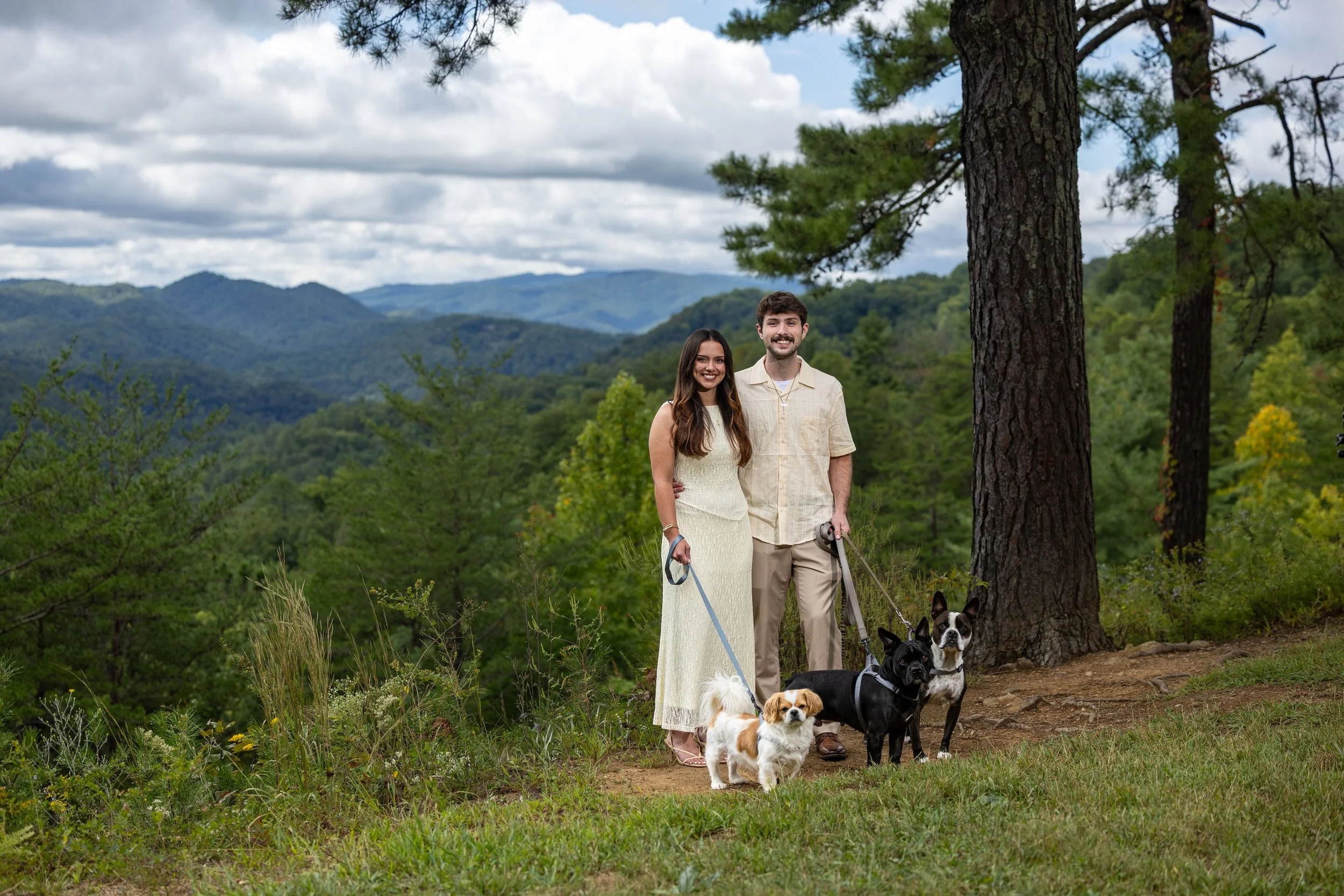 Couple standing with their three dogs at a scenic mountain overlook in the Smoky Mountains.