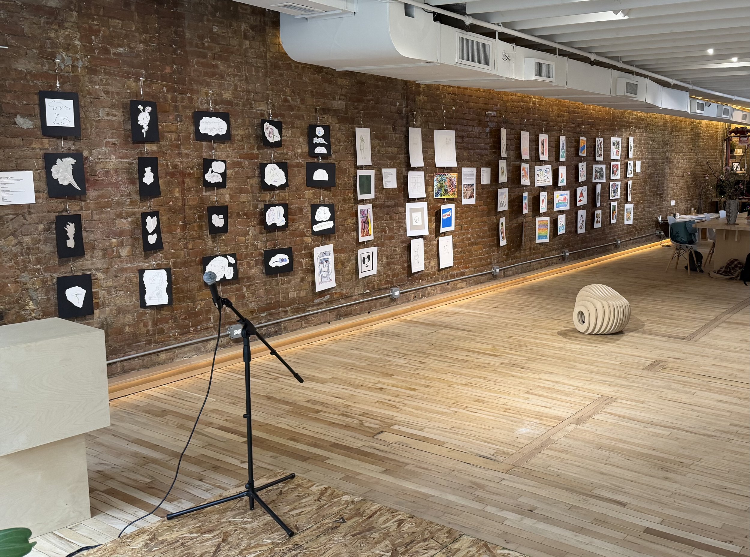  Image of front wall of gallery space, showing multiple works created by members.  