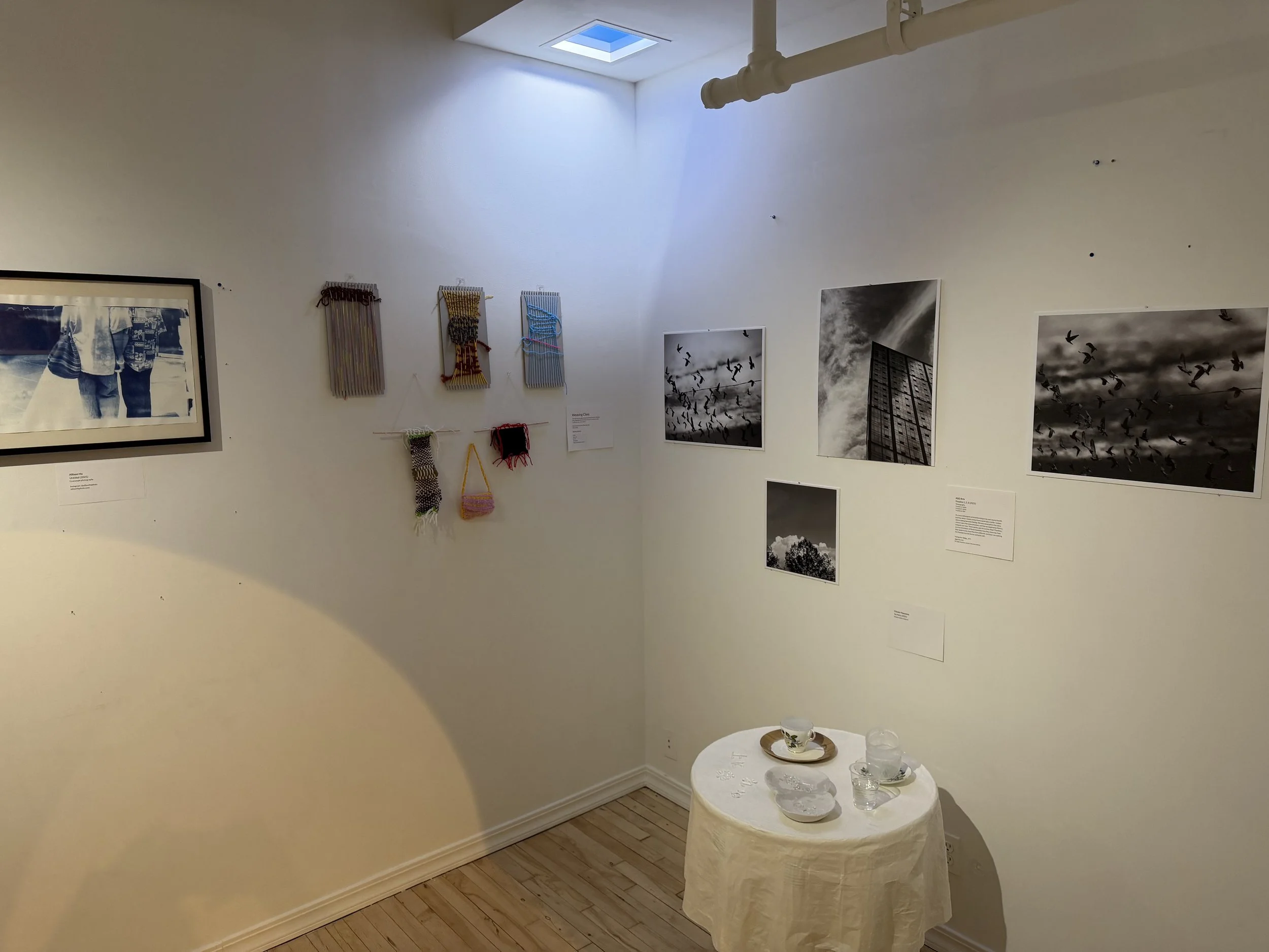  Photo of wall in the gallery, showing photography, weaving works and a mixed media sculpture. 