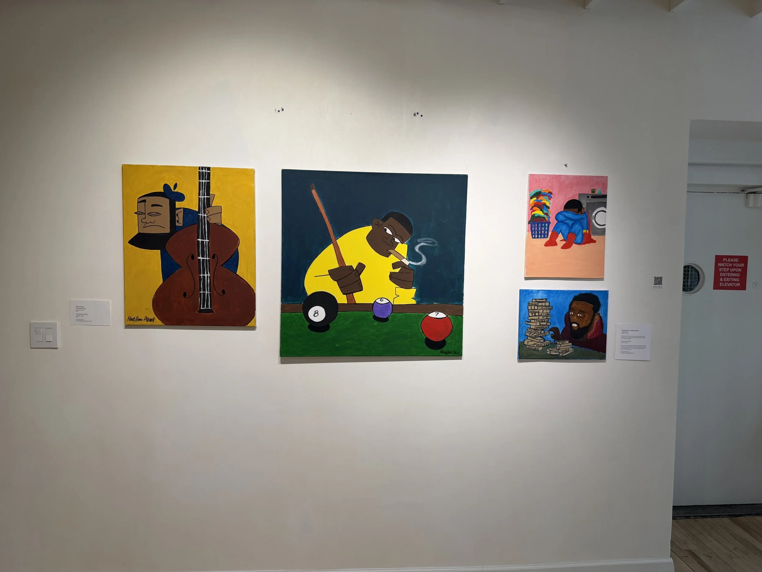  Image of gallery wall showing various portraits and everyday scenes. 