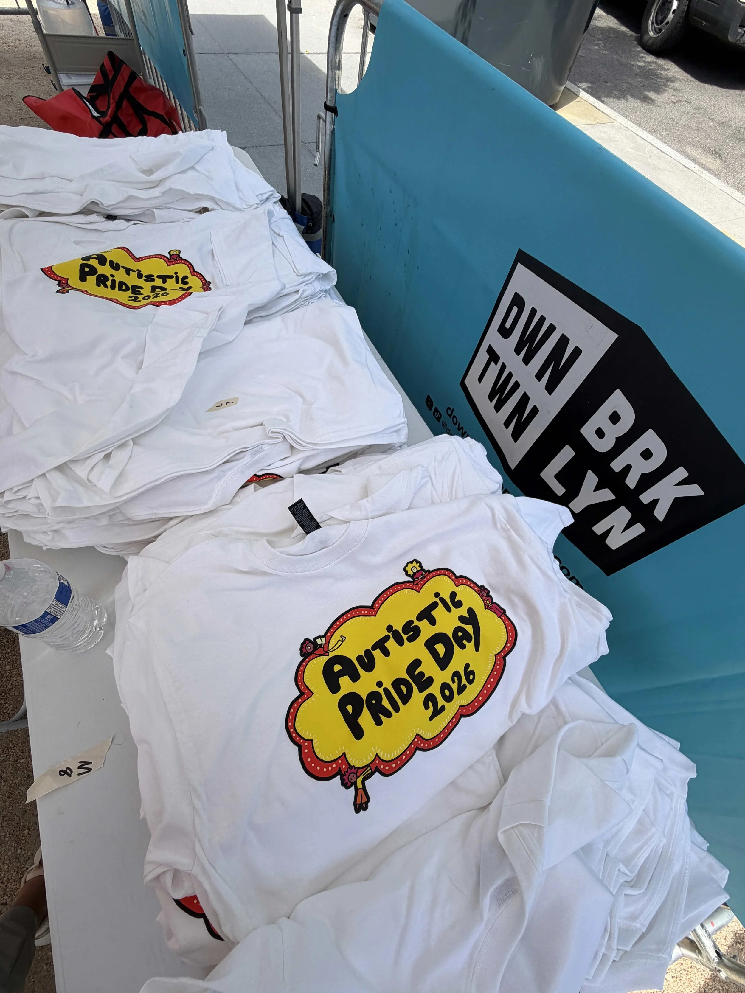  White shirts with the “Autistic Pride Day 2026” logo in the center  