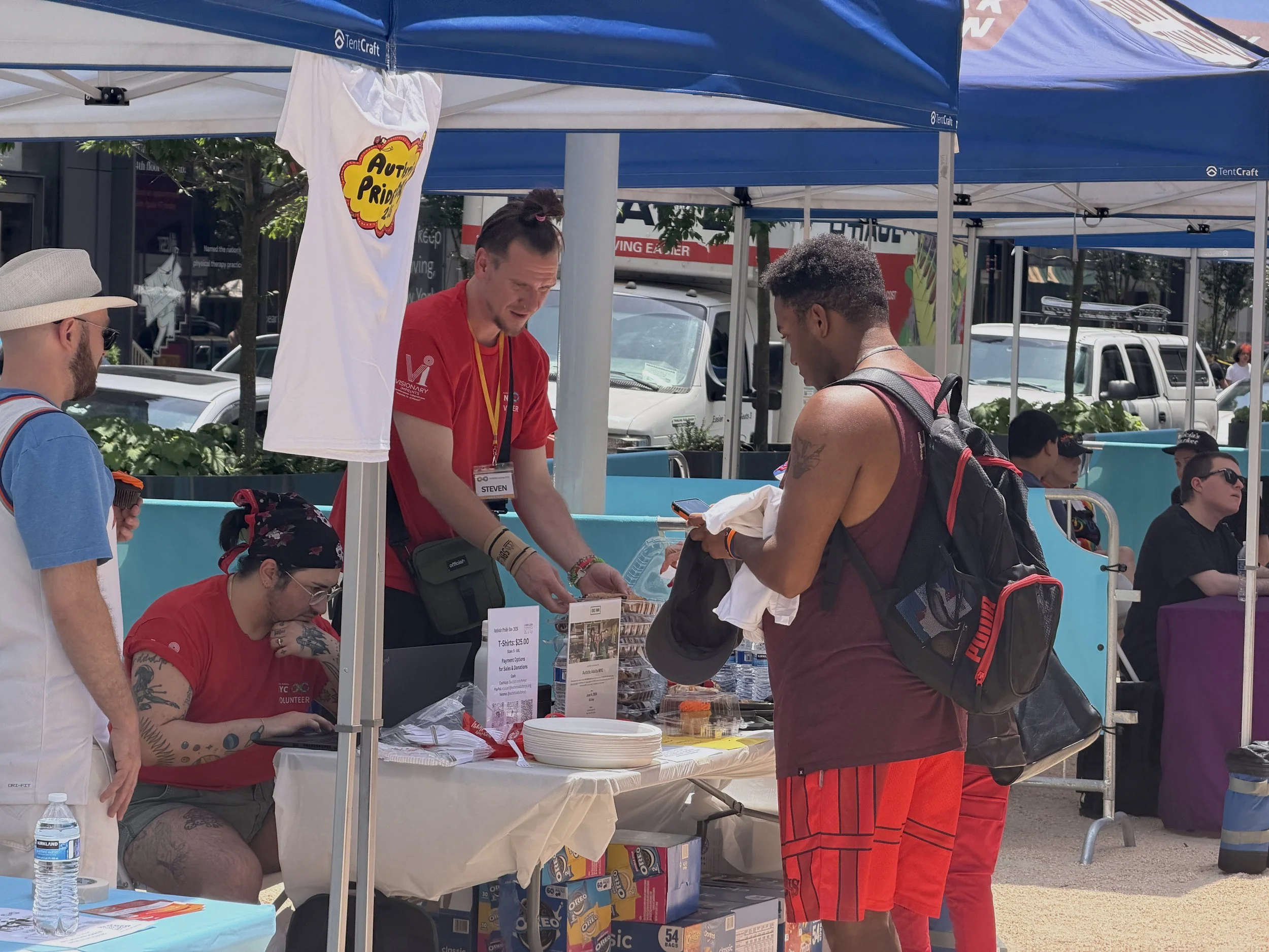  AANYC volunteers selling shirts to an attendee 