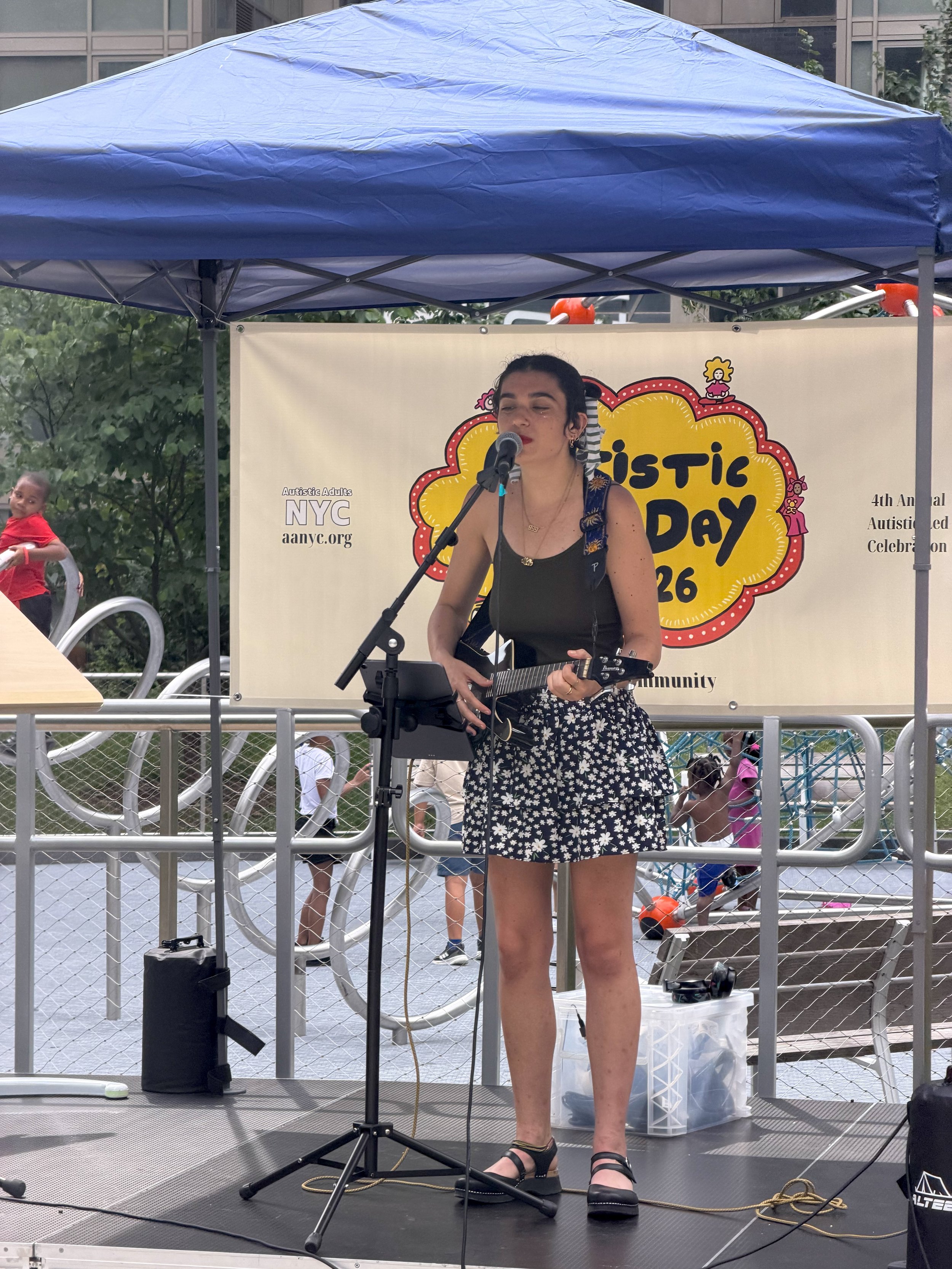  Person singing on stage holding an electric  ukelele 