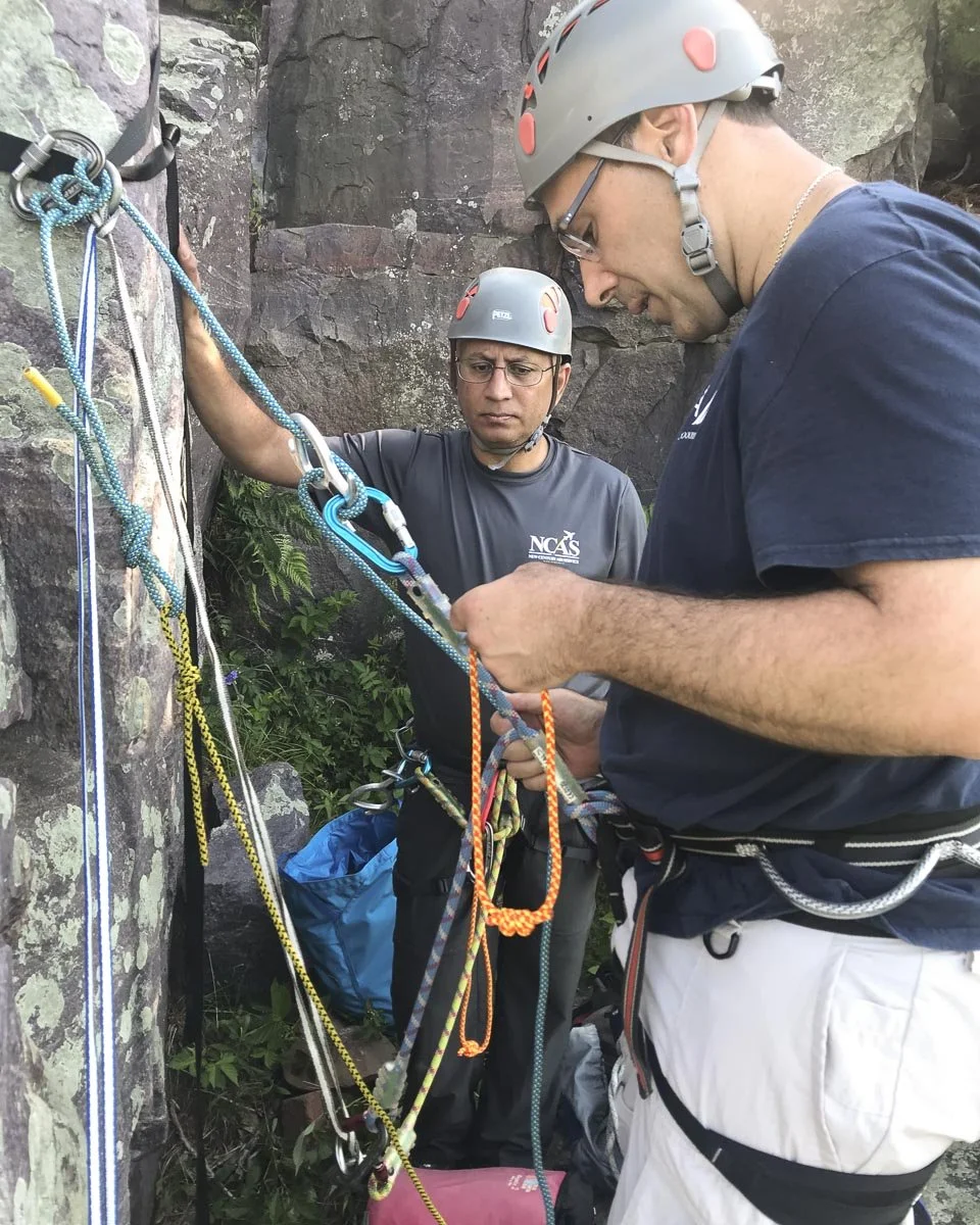  Two students rig a rappel and the pull cord in a single rope rappel setup.  