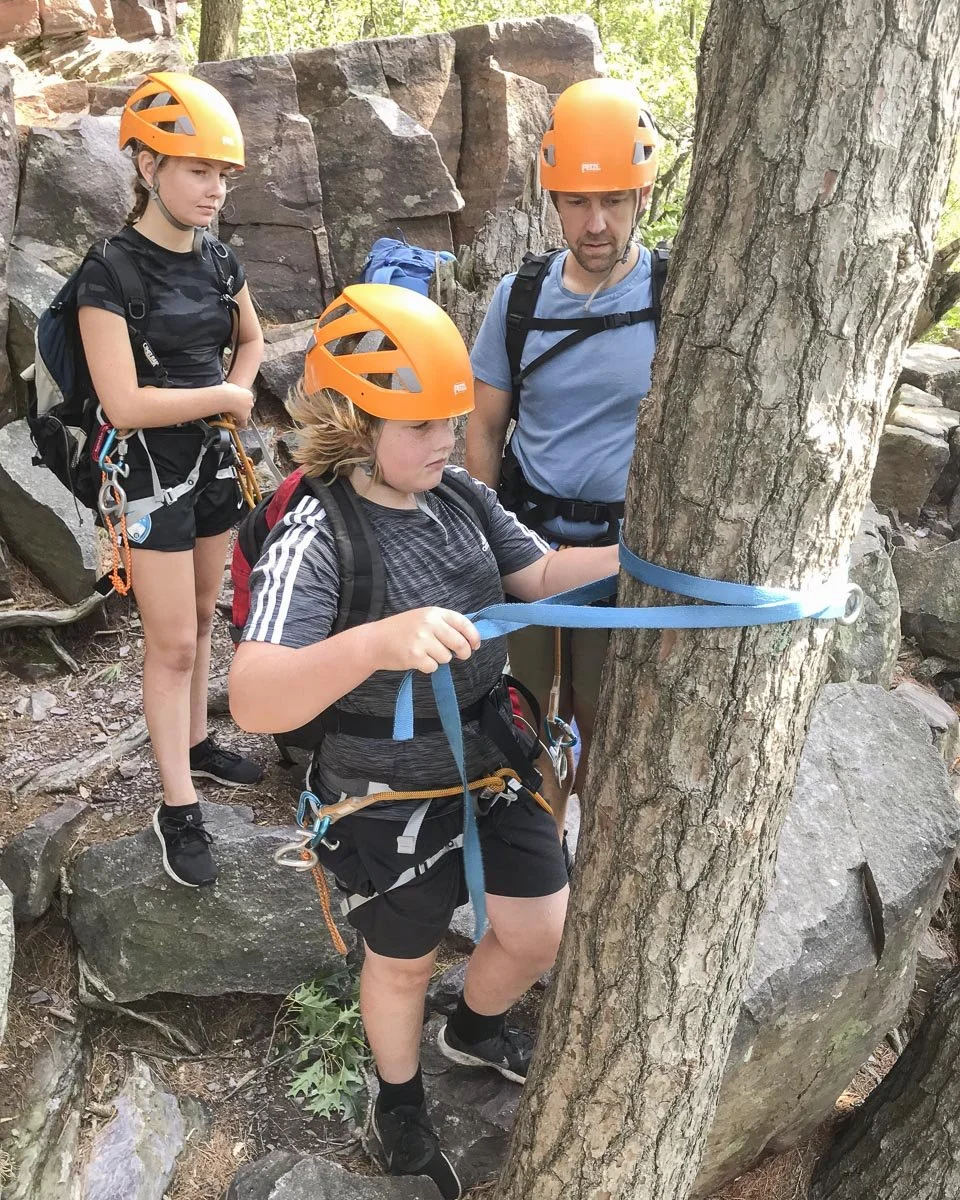  Dad and sis watch as this student independently rigs his first rappel anchor. 