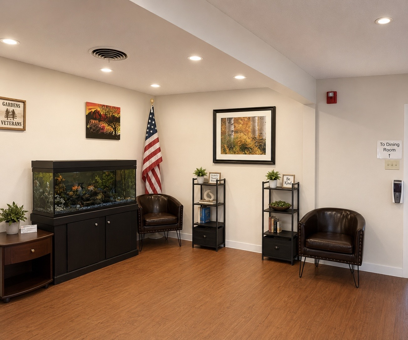 A lounge area with leather chairs, a fish tank, an American flag, and artwork on the walls.