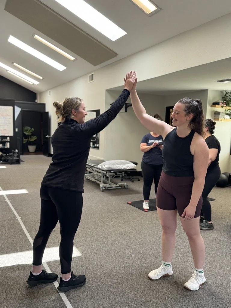Client high-fiving her personal trainer 