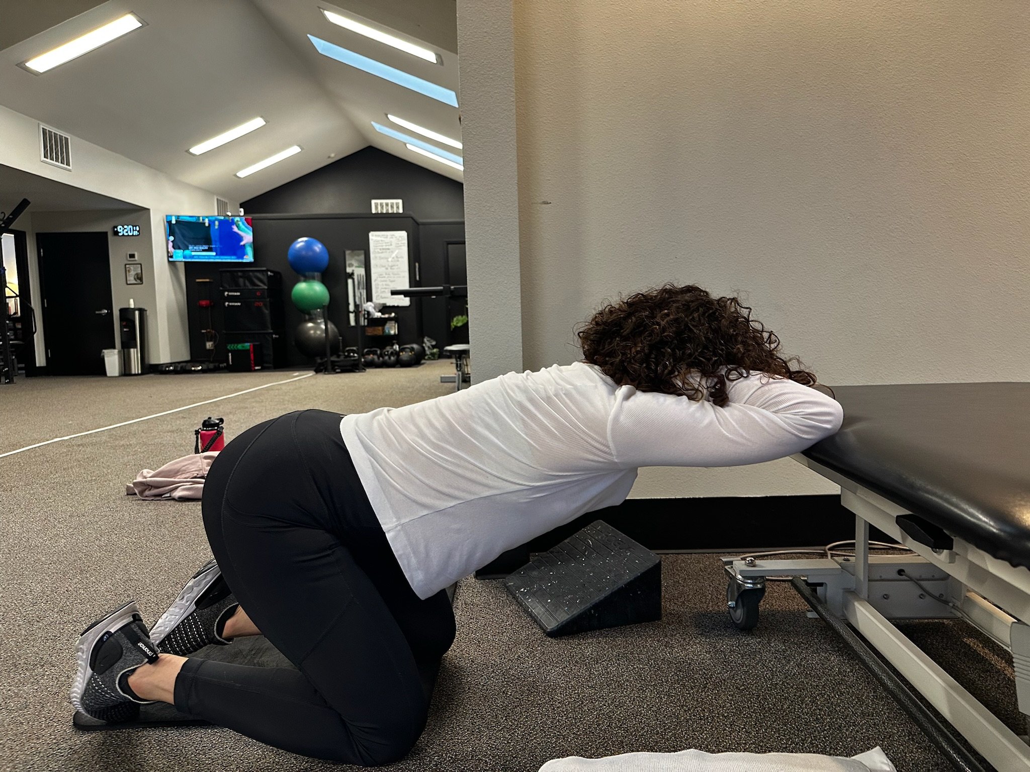 patient stretching shoulder and back