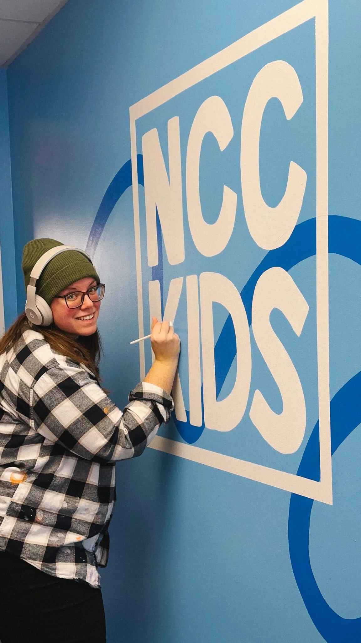 Paxton painting a NCC Kids Logo Mural