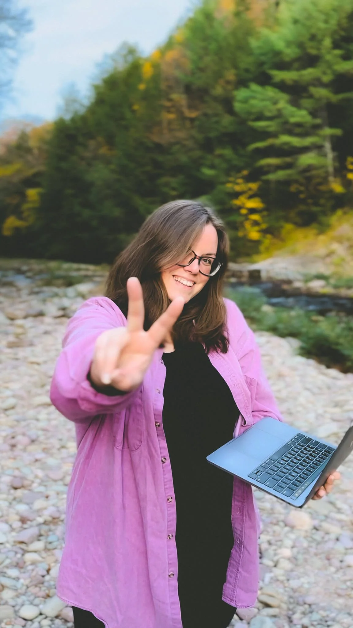 Paxton Creative Co with laptop by a creek