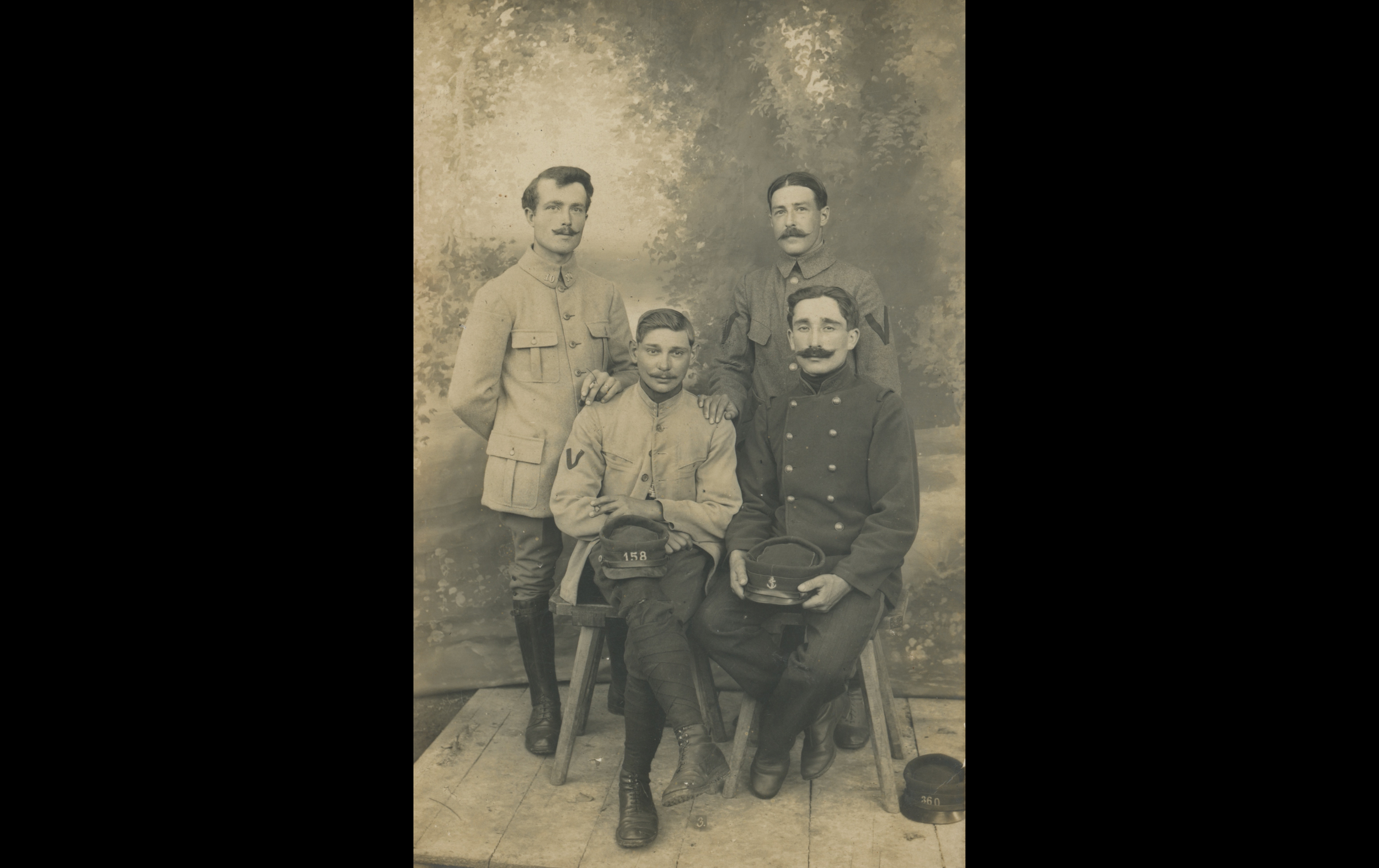 (POW.5.A) Group photo of French prisoners in a studio
Date: 1915 - 1918
Location: Ingolstadt, Germany
Unit: Diverse regiments (20th Battalion of Chasseurs à Pied)
Author: Paul Auguste DELHOUGNE
Present in the photo: 
1. Paul Auguste DELHOUGNE (Mle 36