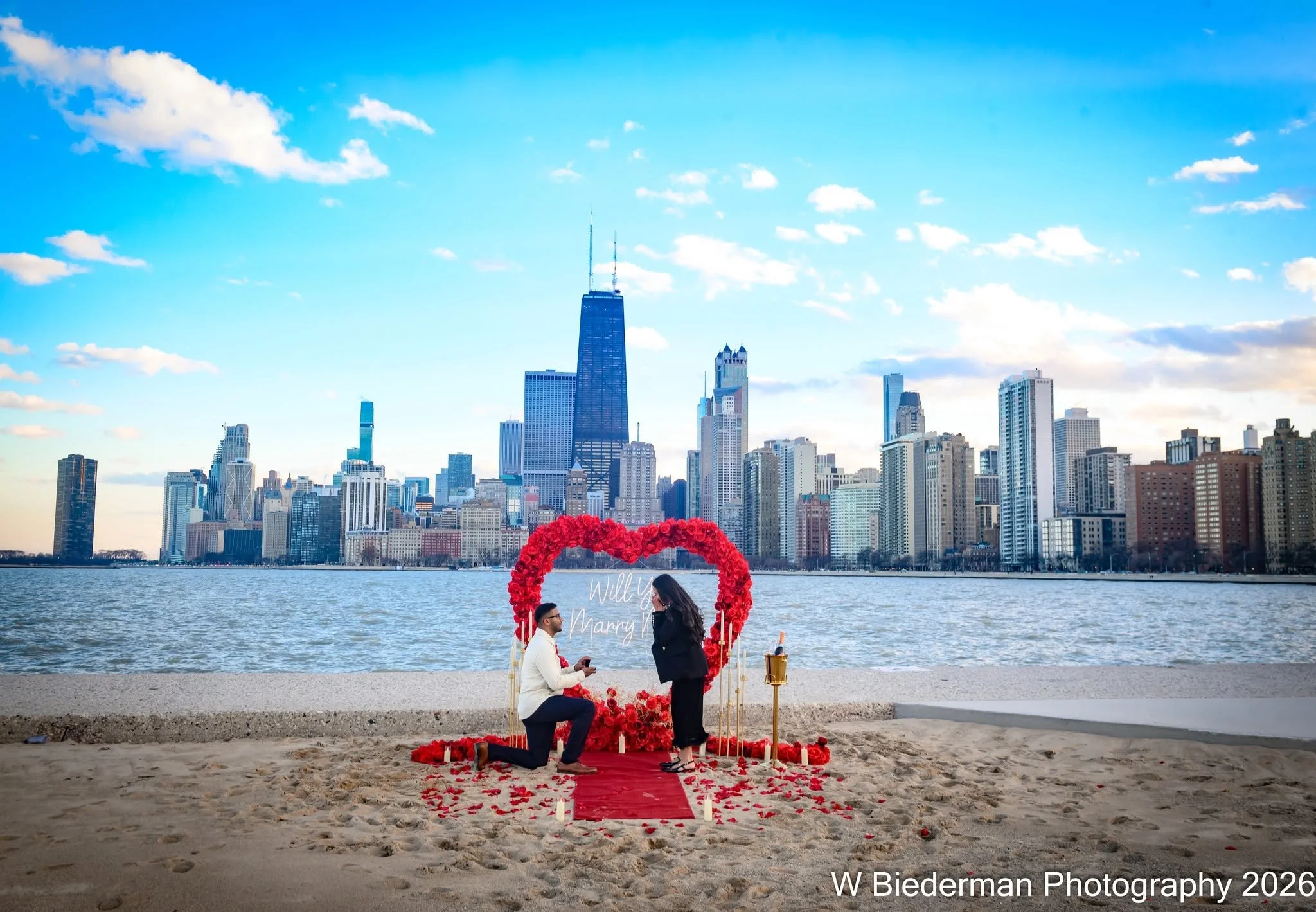 When you're ready to pop the question, why not pull out all the stops? ❤️💍 This romantic boyfriend spared no expense, bringing rose petals, champagne, and a beautiful heart-shaped floral display to North Avenue Beach for an unforgettable surprise ma