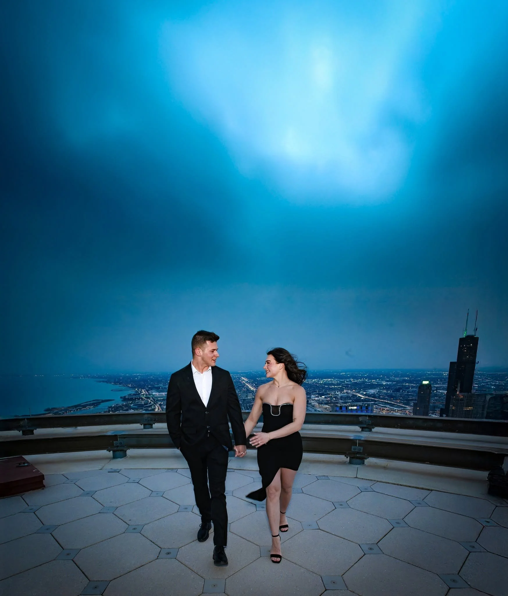 Love above the Chicago Riverwalk! This newly engaged couple shares a romantic rooftop moment overlooking the Chicago skyline, with dramatic blue skies creating the perfect backdrop. From breathtaking rooftop views to iconic downtown locations, Chicag