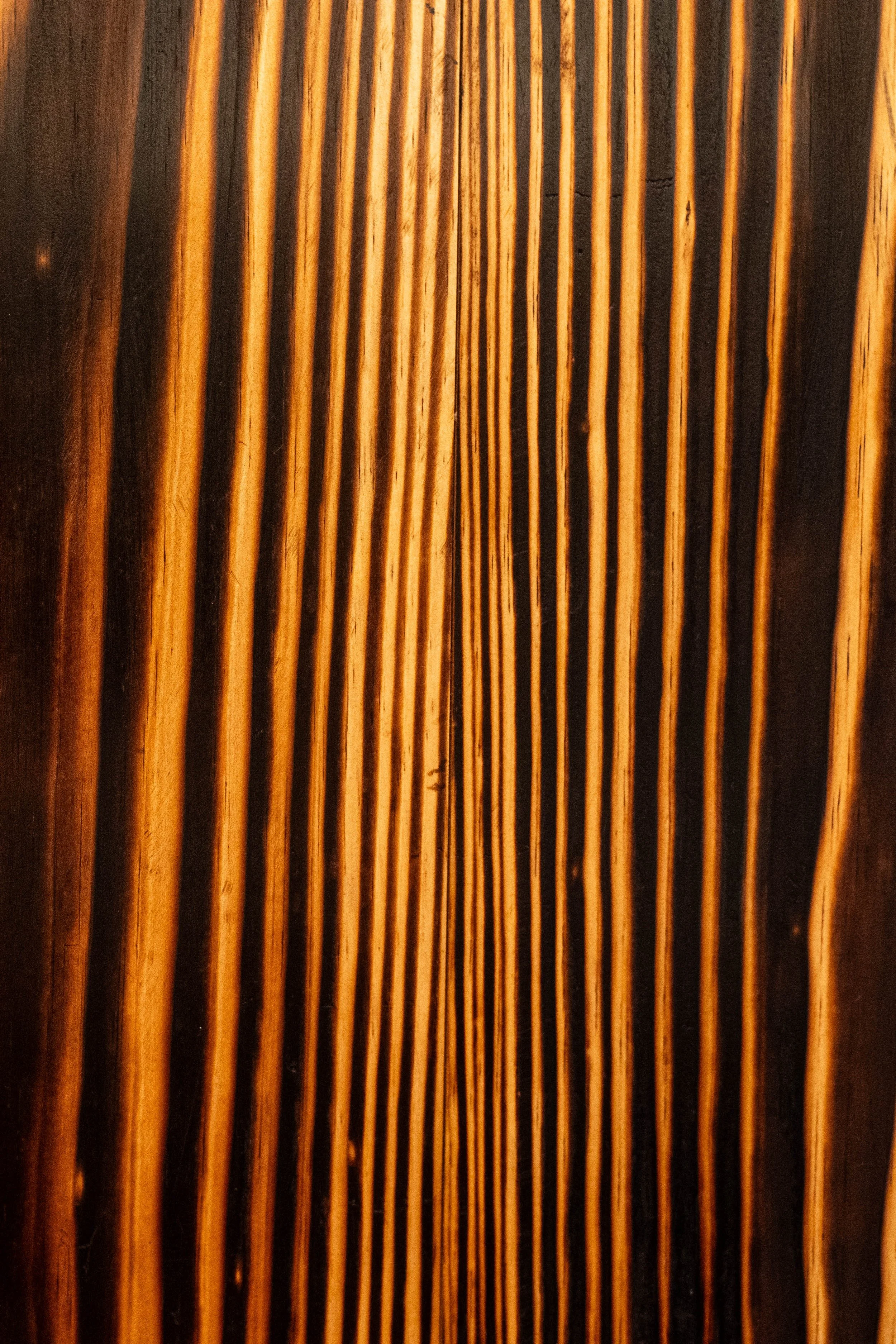 Wooden texture with grooves in shades of brown and almost black.