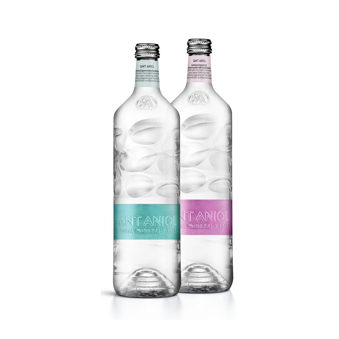 Two bottles of Sant Aniol natural mineral water with clear, textured glass bottles and light blue and pink labels.