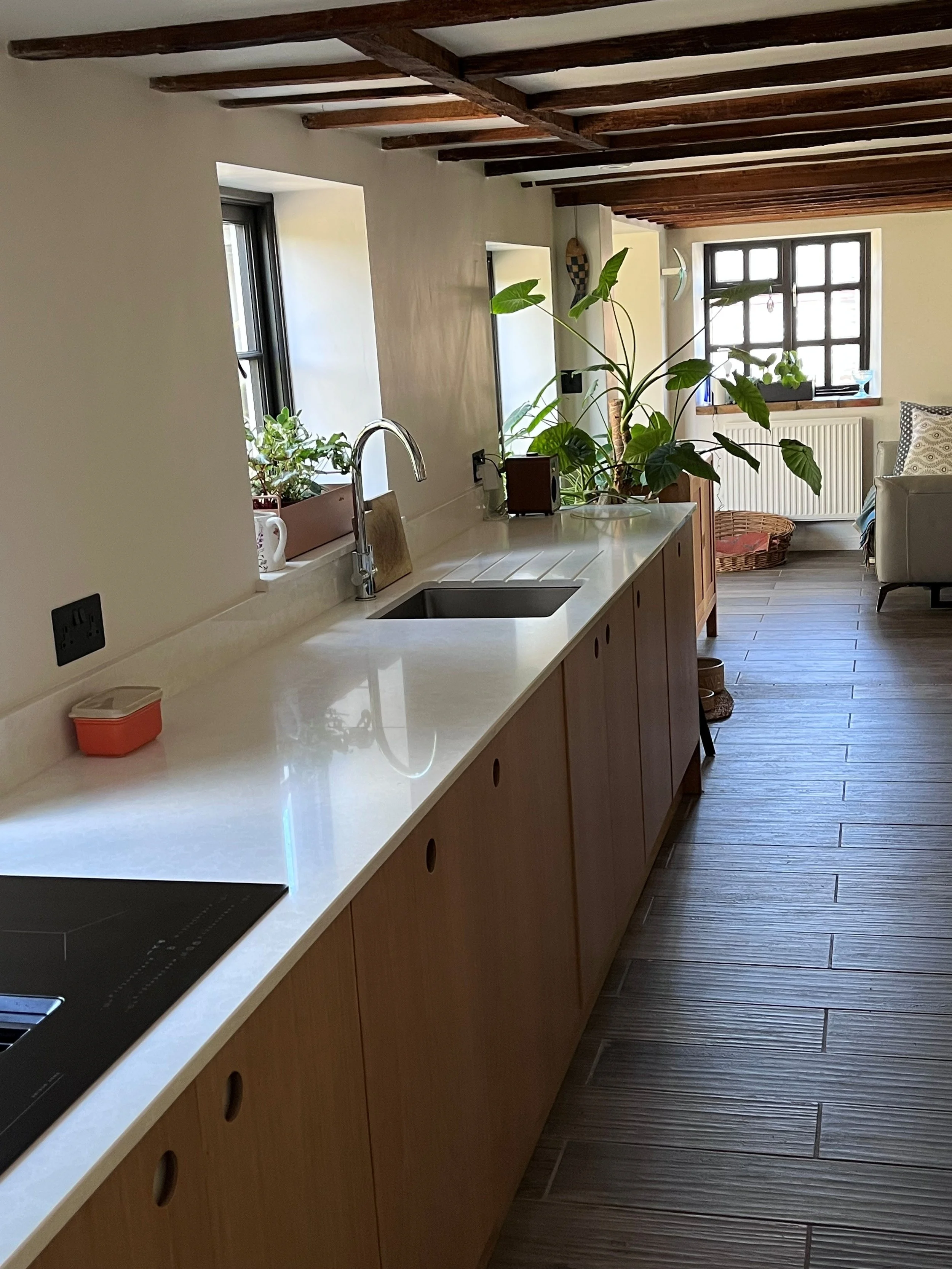 A modern country kitchen with ply units and stone worktop