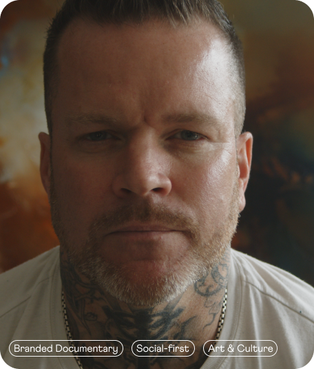Close-up of a man with short hair and a beard, looking directly at the camera with a serious expression.