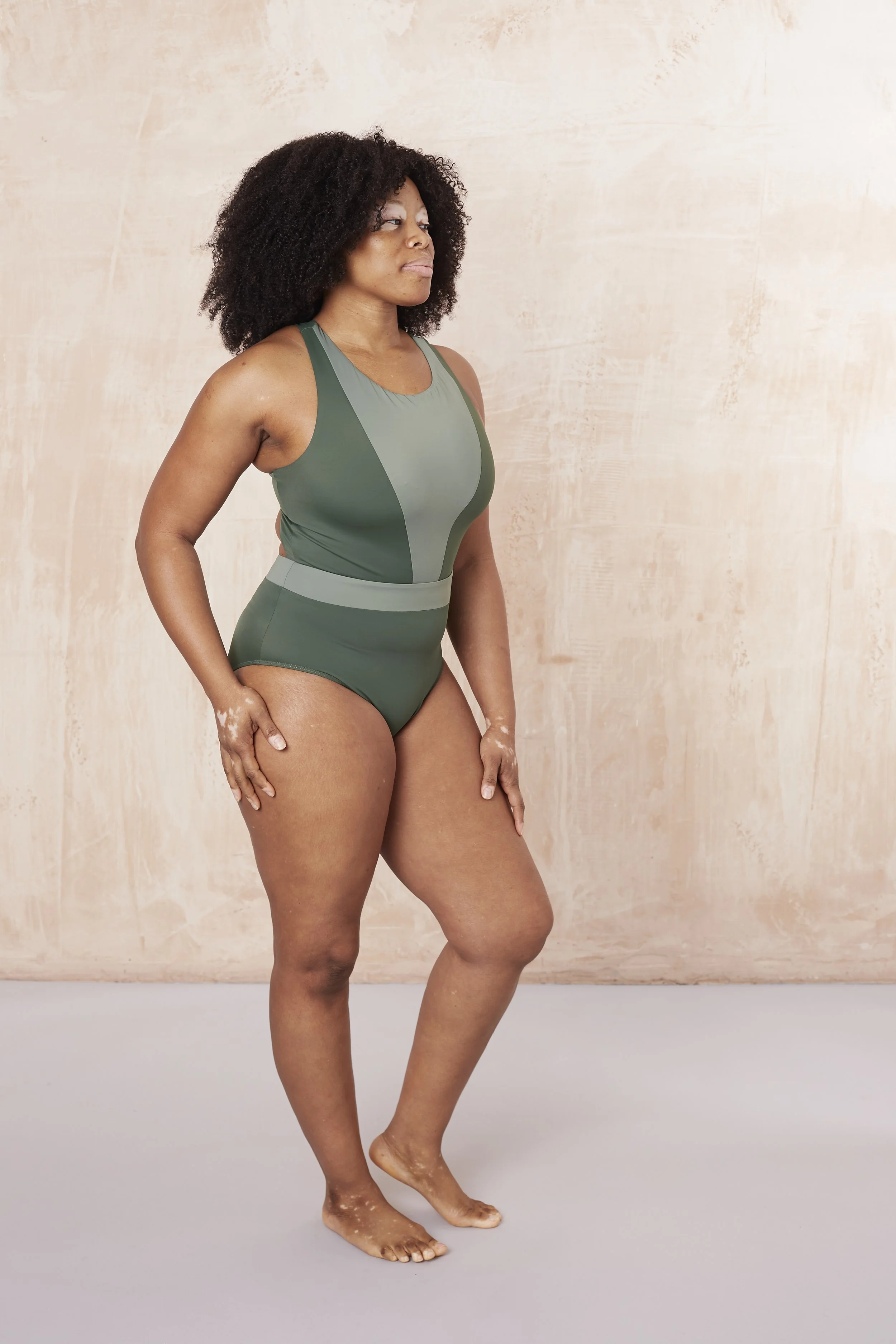 Side view Brook swimsuit in contrasting green colour. V shaped front panel provides support and coverage. Medium cut leg.