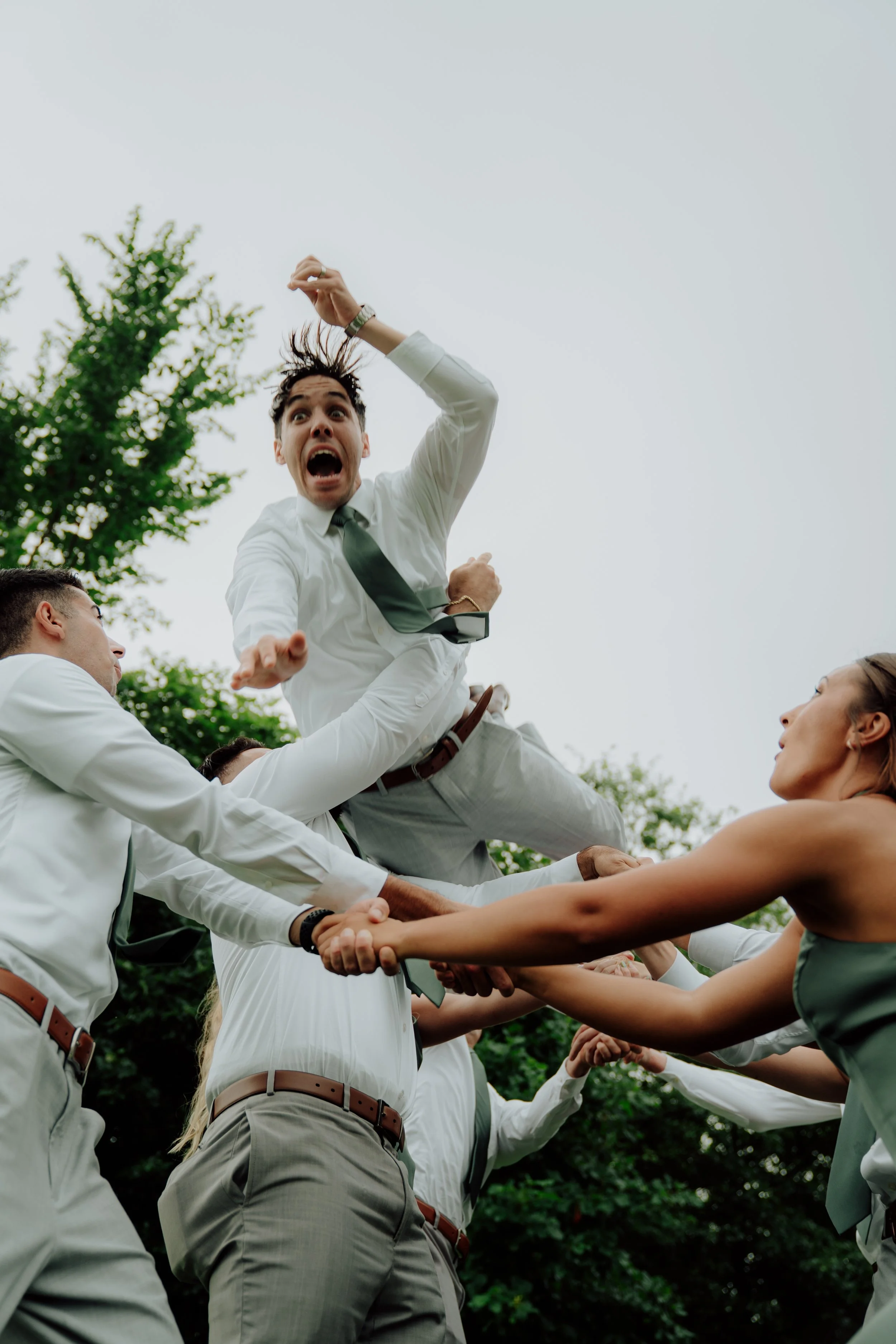 People participating in a traditional human tower formation, known as a 'castell,' outdoors with trees in the background.