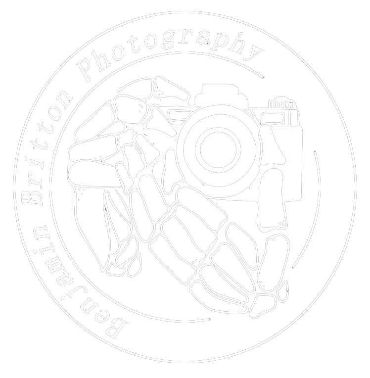 Black and white logo with a skeletal hand holding a camera, surrounded by the text 'Ben J. Britton Photography' in a circular arrangement.