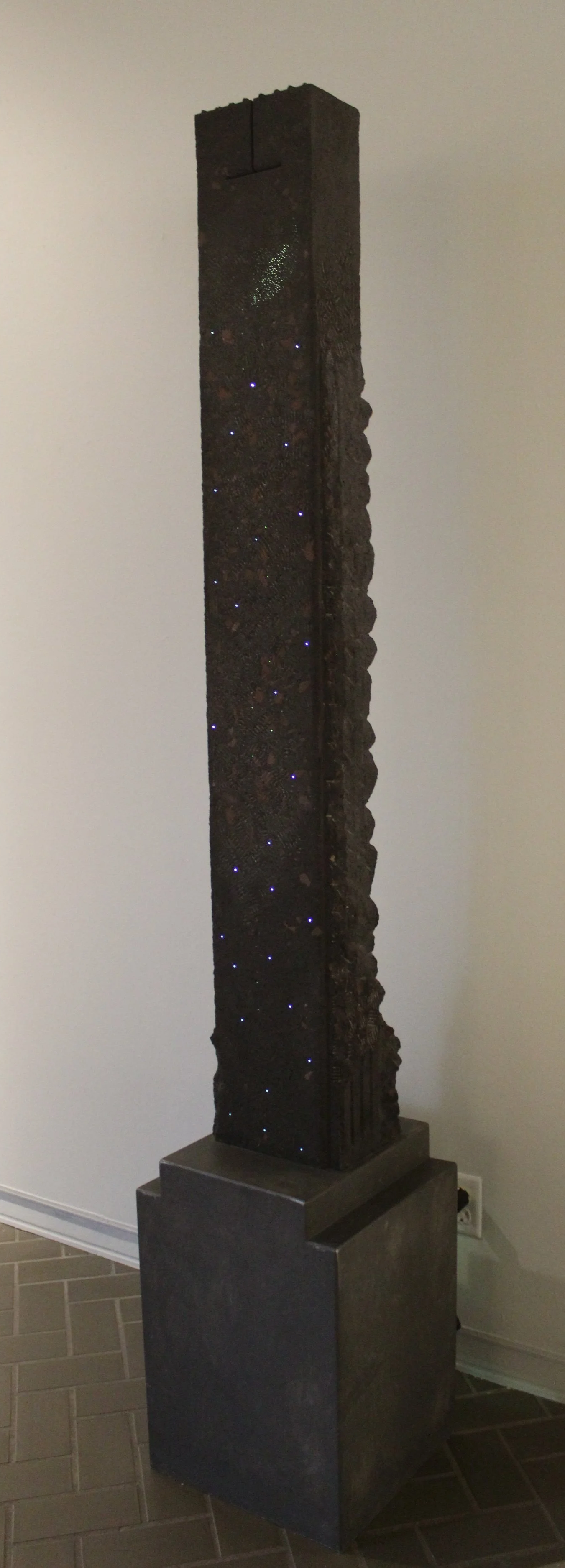 Clyde Lynds (American 1936) “Stele XXI”, 1996, cast cement with fiber optics, gift of Jeff Parker, 1998 (83’’ H x 14’’ W x 5’’ D”)