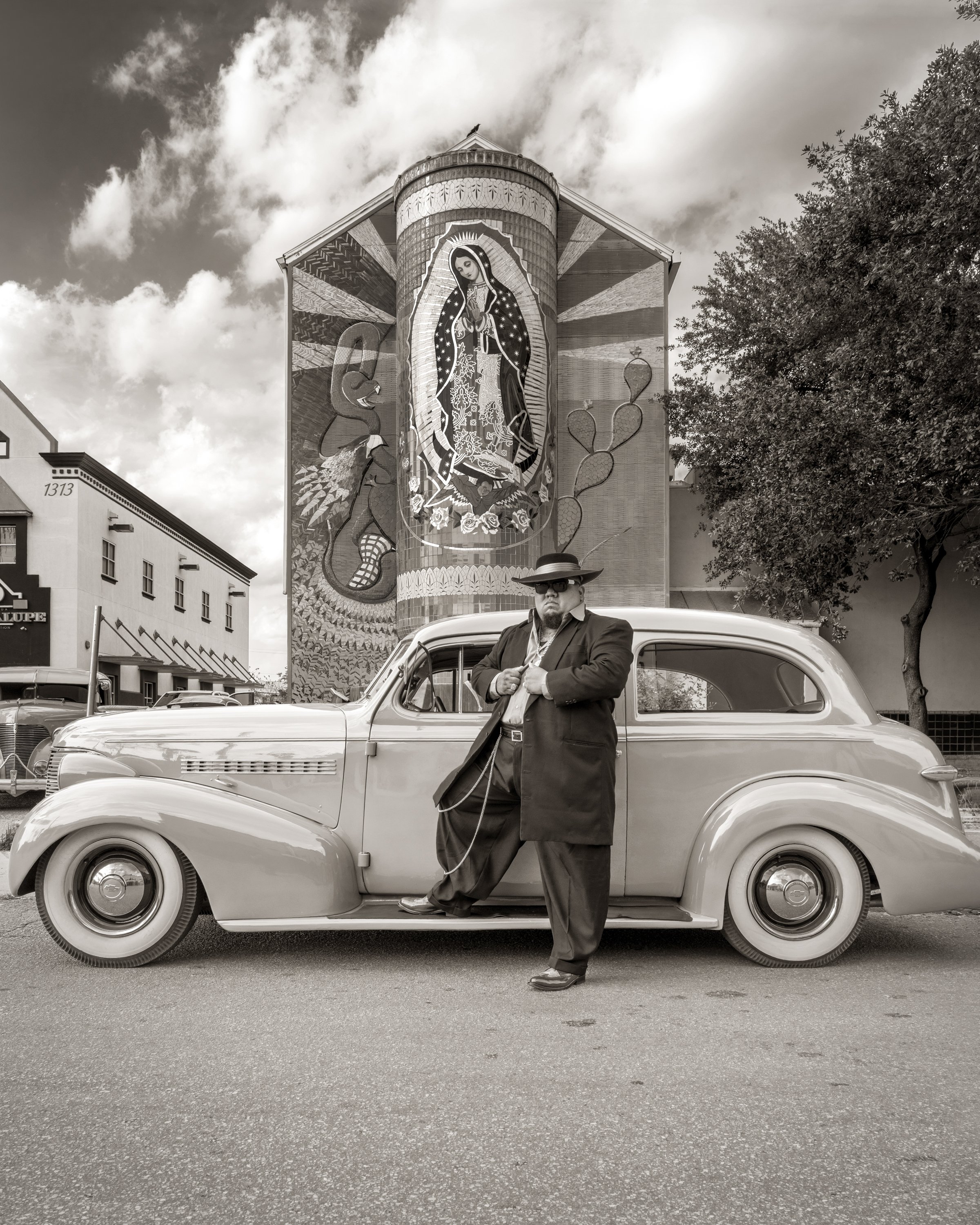 Al Rendon, "Jose Mosqueda with 1938 Chevrolet Master Deluxe, Mural by Jesse Trevino at Guadalupe Cultural Art Center". ©2023 Al Rendon.