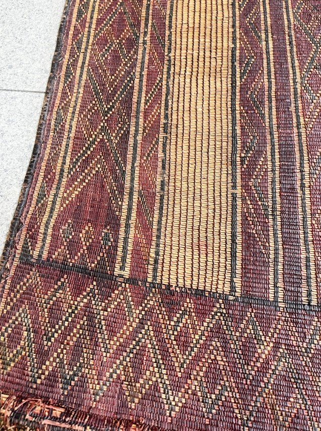 Saharan Desert. 20th-century Tuareg woven rug made of leather and reed. Dimensions 132cm x 88cm. The design consists of diamond and linear patterns in an earthy palette of browns, dark reds, black, and straw yellow. Rights Cafiero Select. Accessed vi