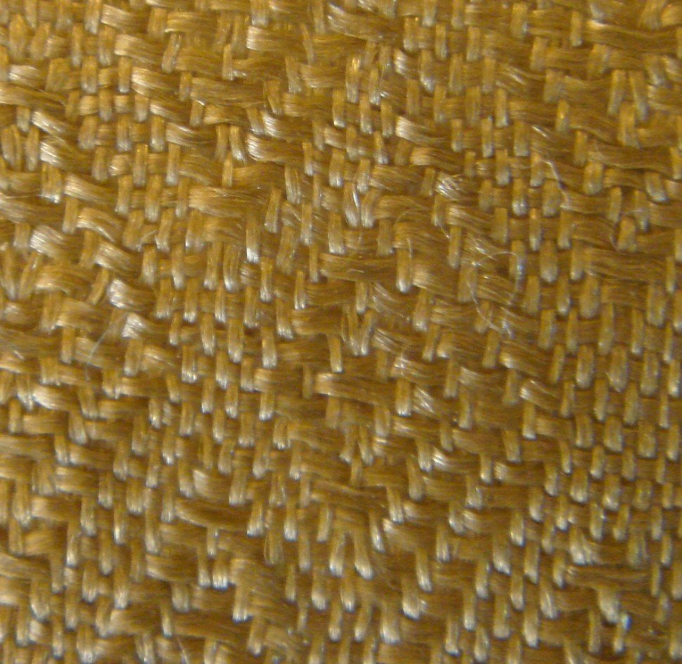 China. Dunhuang Province. Streamer. This yellow-brown banner streamer, possibly a side or bottom streamer, is in a fragmentary condition. Dimensions 54.6 x 5.1 cm. It is made of damask on plain weave with a concentric diamond pattern, repeated 1.1 cm