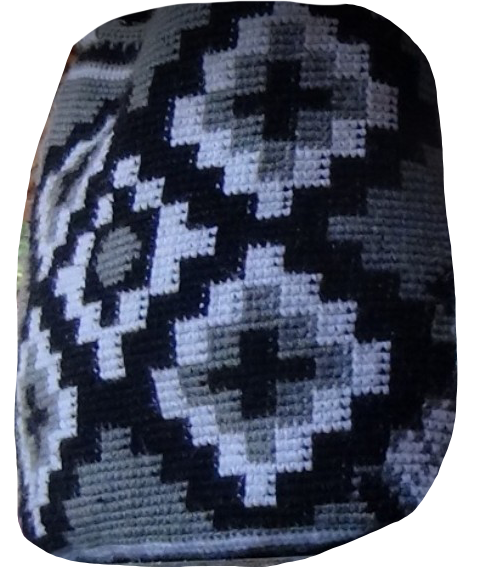 Woolen backpack with three meanings. “The dark part represents all the problems and conflicts that surround us,” says the artisan, adding that the white color symbolizes “purity, innocence, and peace.” The geometric designs, composed of rhombuses, re