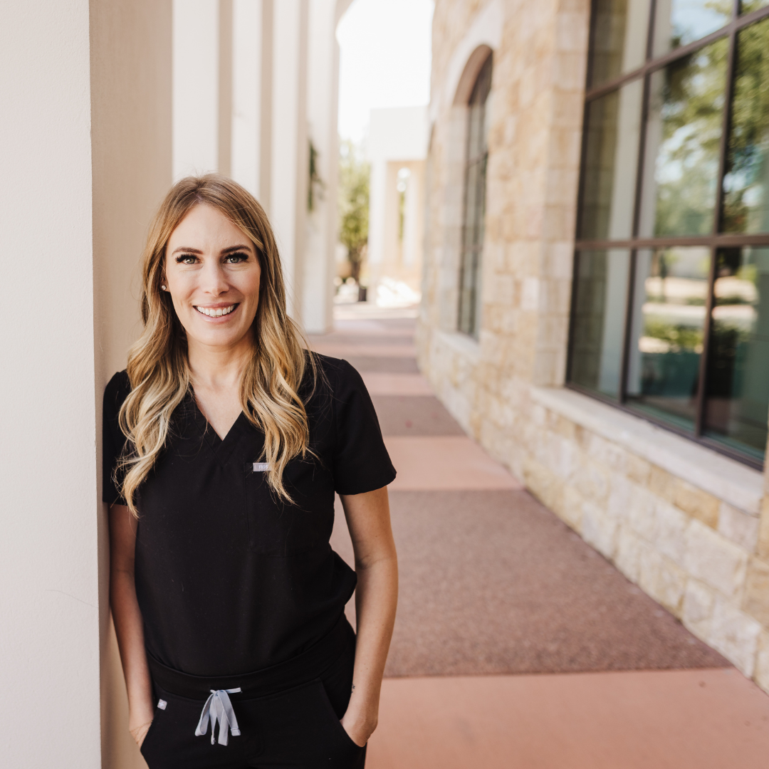 a professional woman smiling with her hands in her pockets